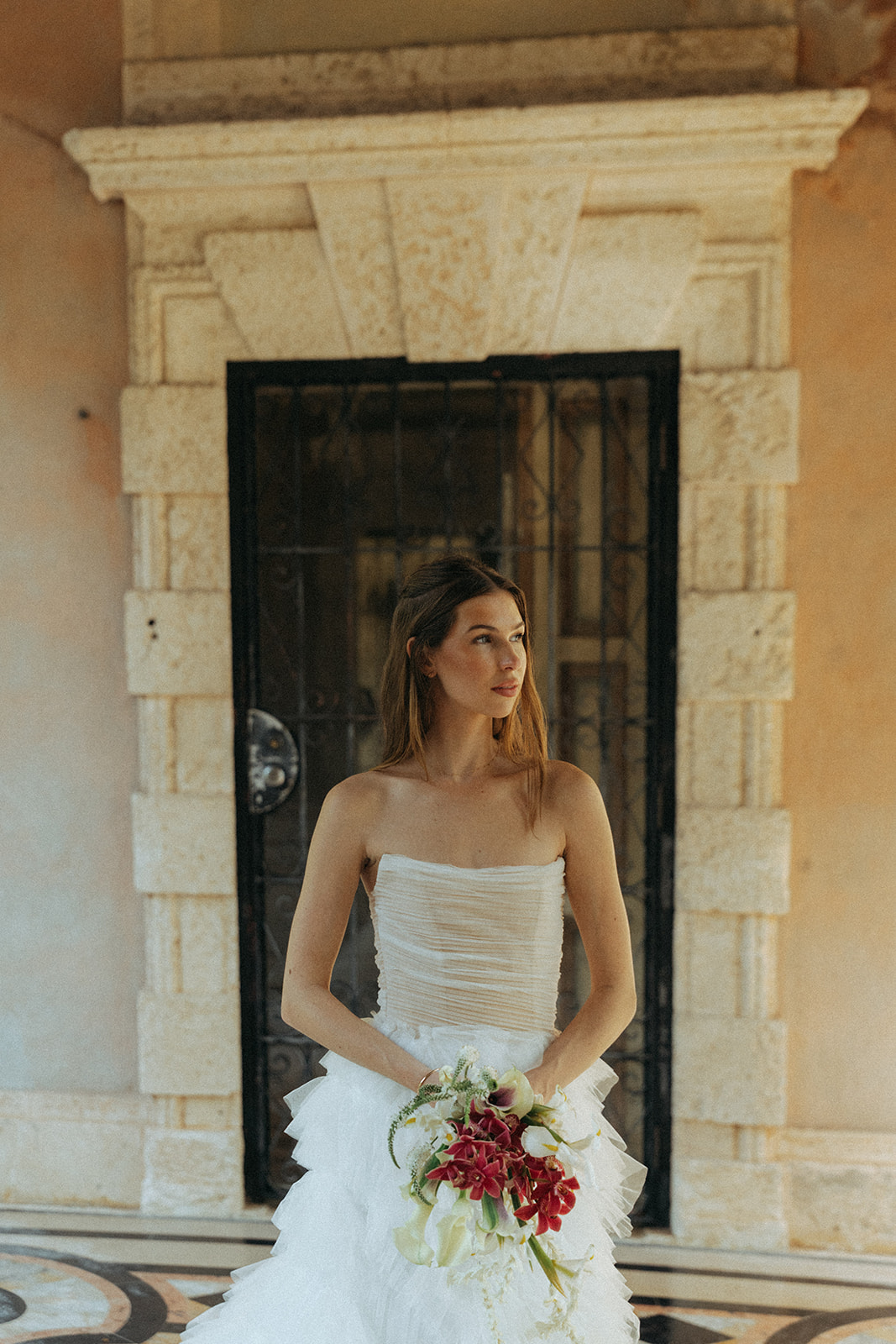 Viscaya Bride looks off camera holding her bouquet in her white dress by Vizcaya Wedding Photographer Elsie Goodman.