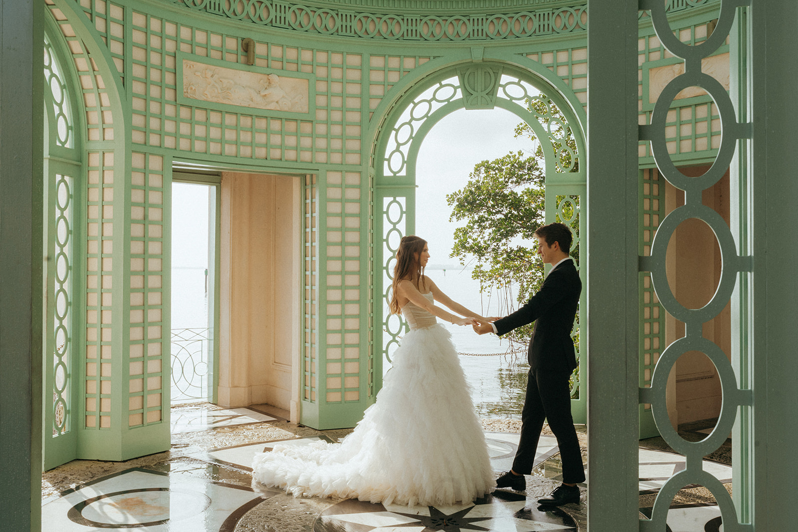 Bride and groom hand in hand dance in the gazebo by Vizcaya Wedding Photographer Elsie Goodman.