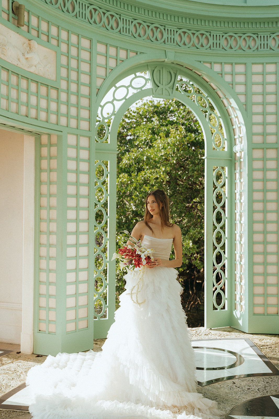 Viscaya Bride holding her bouquet in the gazebo looking away from the camera by Vizcaya Wedding Photographer Elsie Goodman.