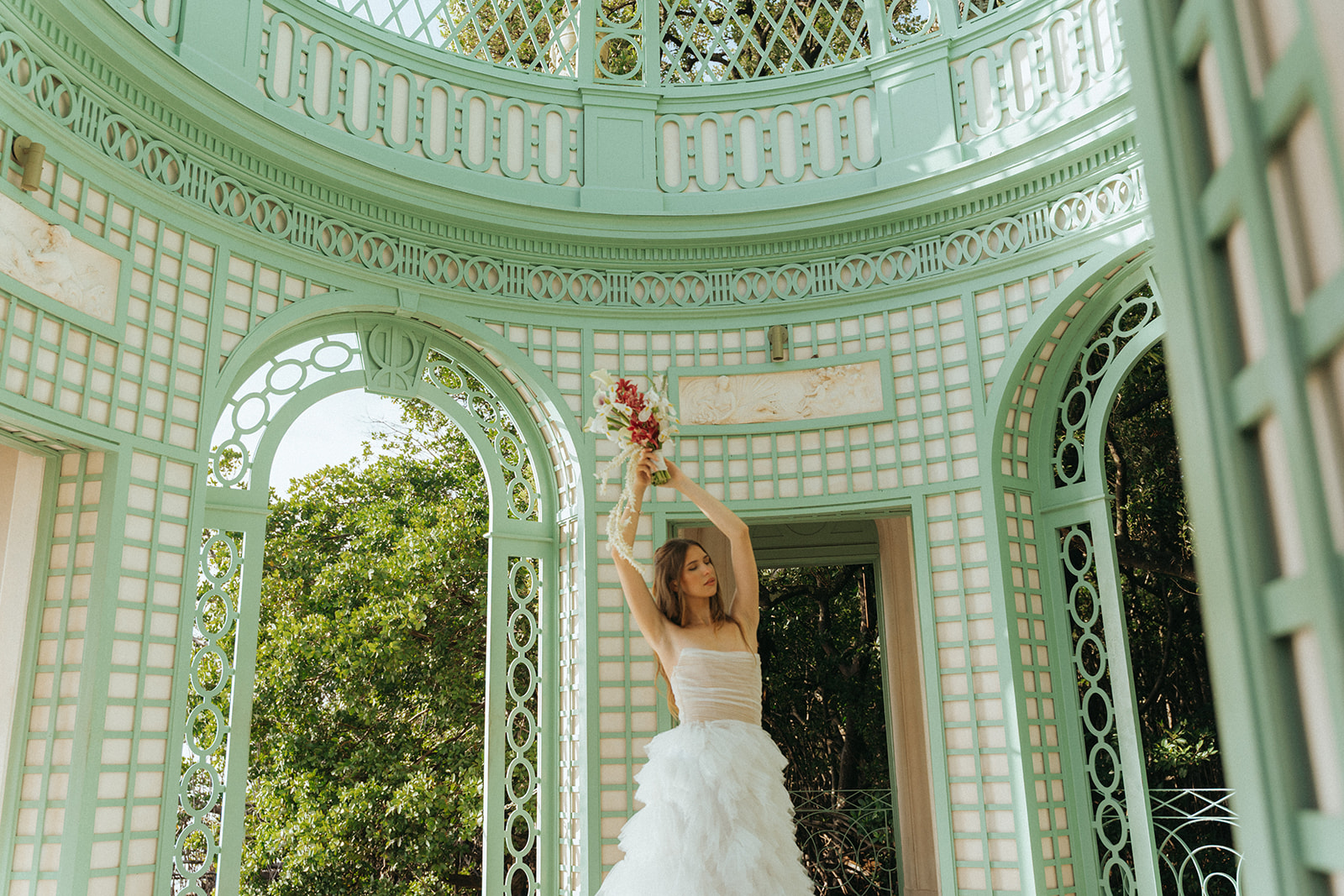 Viscaya Bride holds her bouquet above her head in the gazebo by Vizcaya Wedding Photographer Elsie Goodman.