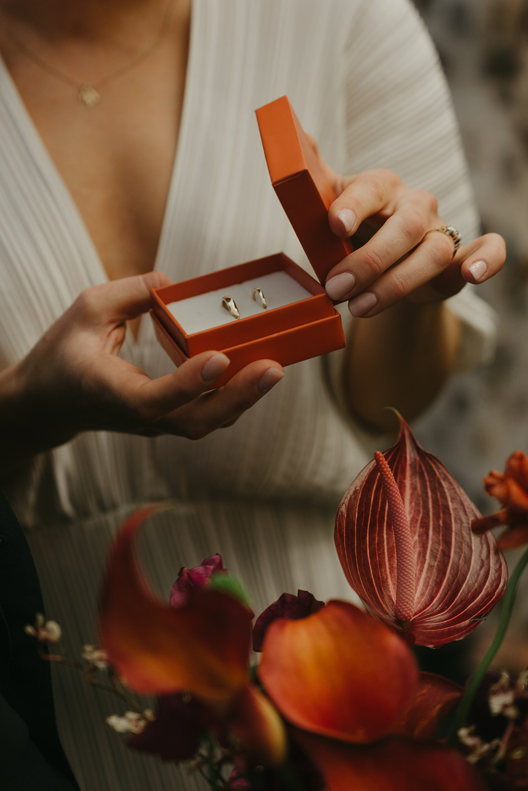 Rachel and Dave’s 2 day celebration bride opening the ring box, showing two gold rings inside, her bouquet is in the corner of the frame by NYC city hall wedding photographer Elsie Goodman.