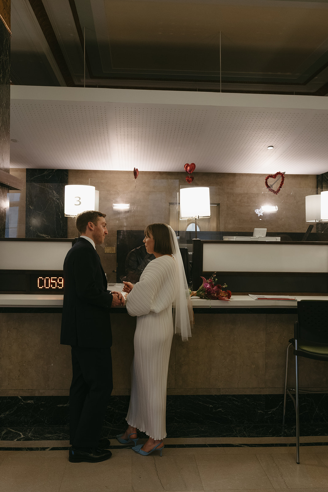 Rachel and Dave’s 2 day celebration Bride and groom at the city hall desk, looking at each other by NYC city hall wedding photographer Elsie Goodman.
