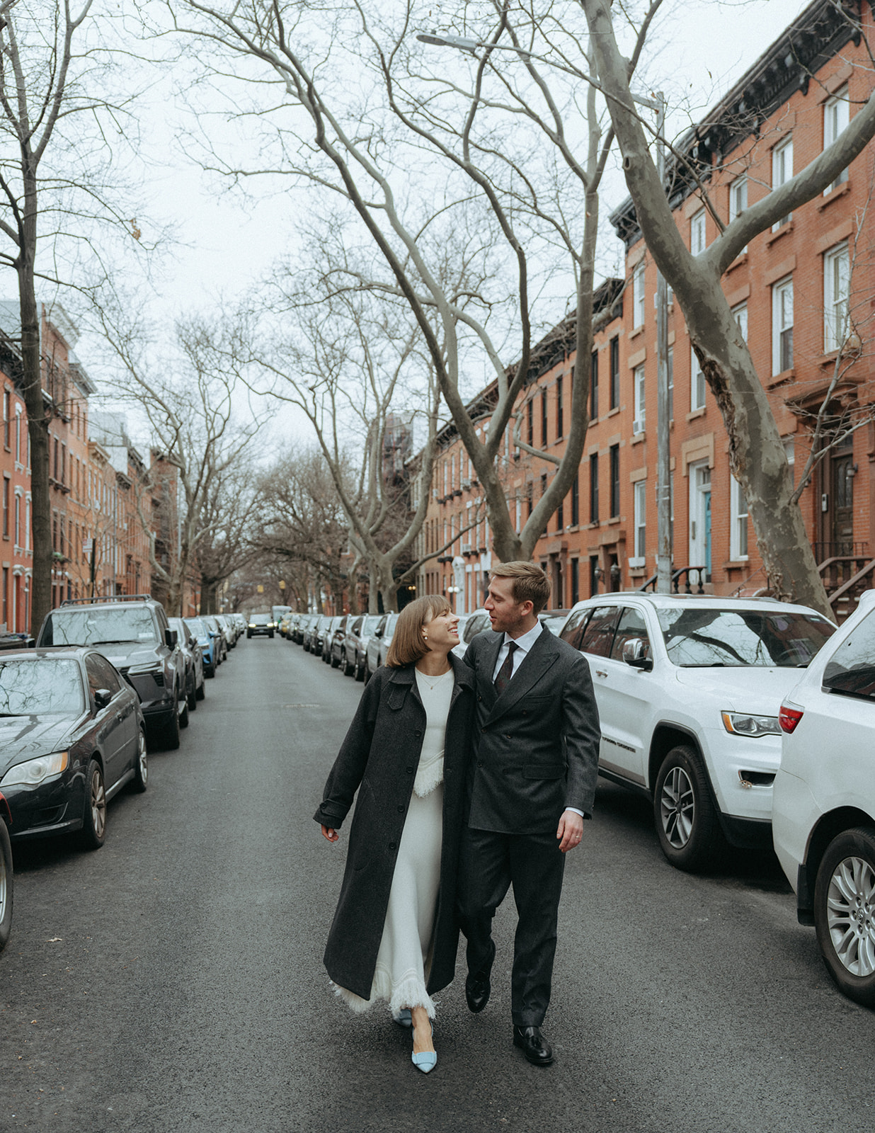 Rachel and Dave’s 2 day celebration Bride and groom walking down a city street by NYC elopement photographer Elsie Goodman.