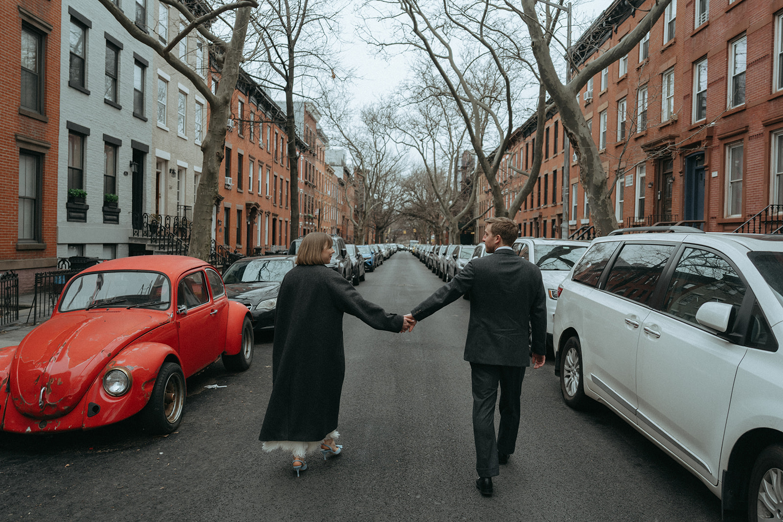 Rachel and Dave’s 2 day celebration Bride and groom walking hand in hand down a city street by NYC elopement photographer Elsie Goodman.