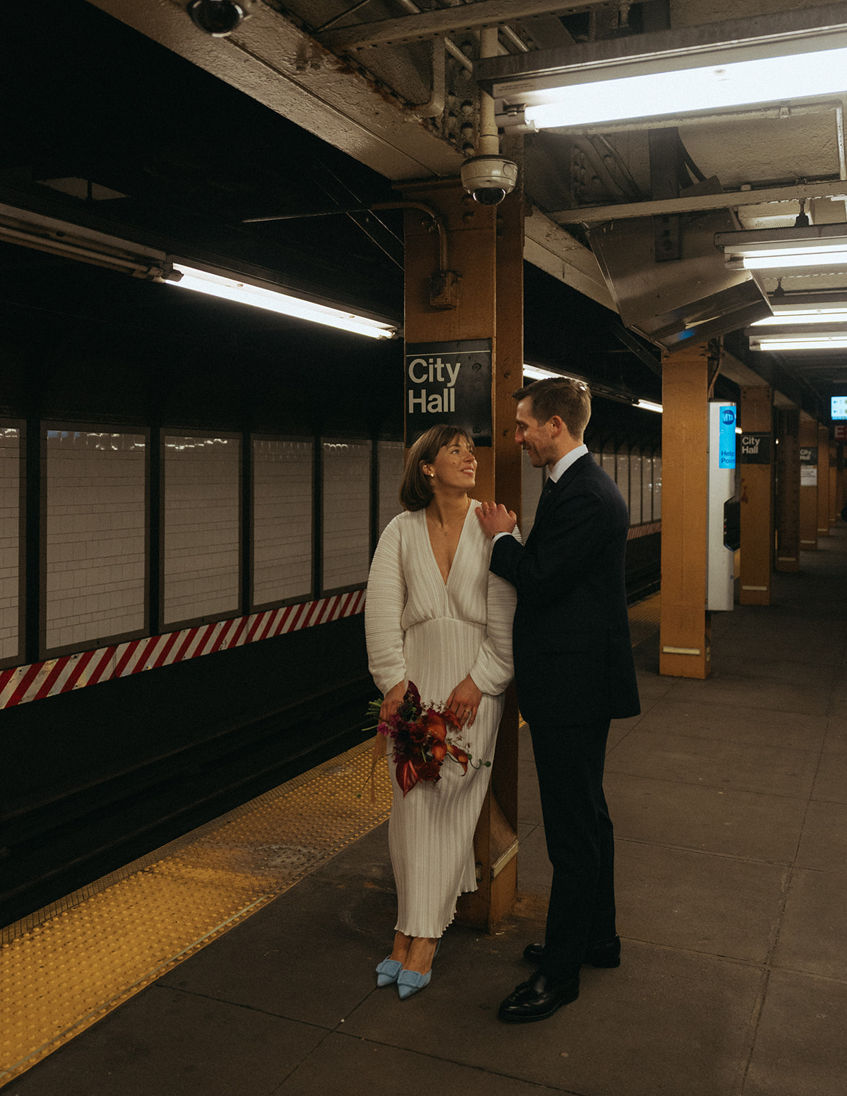 Rachel and Dave’s 2 day celebration Bride and groom leaning against the subway sign for city hall by NYC city hall wedding photographer Elsie Goodman.