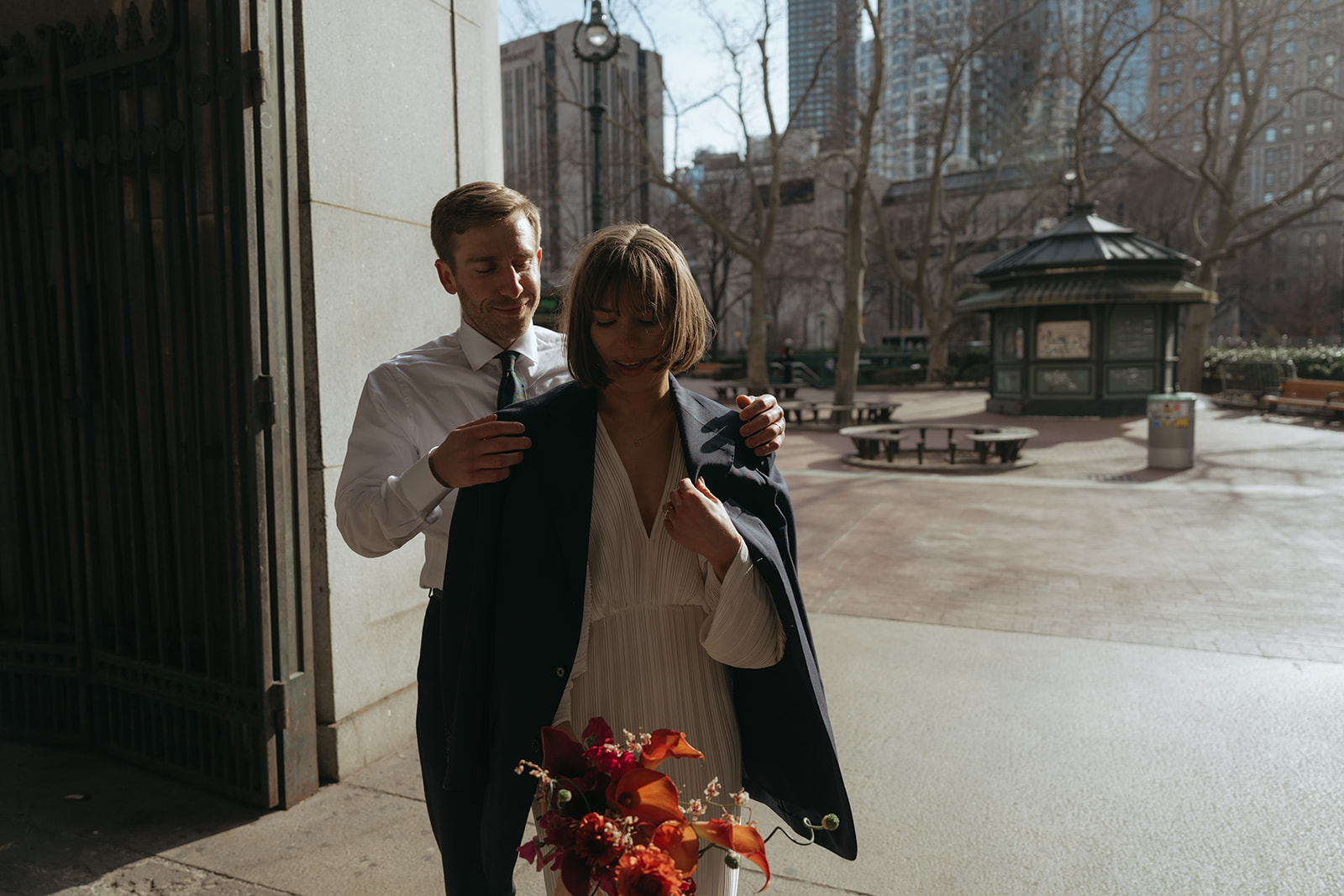 Rachel and Dave’s 2 day celebration Groom puts his jacket over the bride by NYC city hall wedding photographer Elsie Goodman.