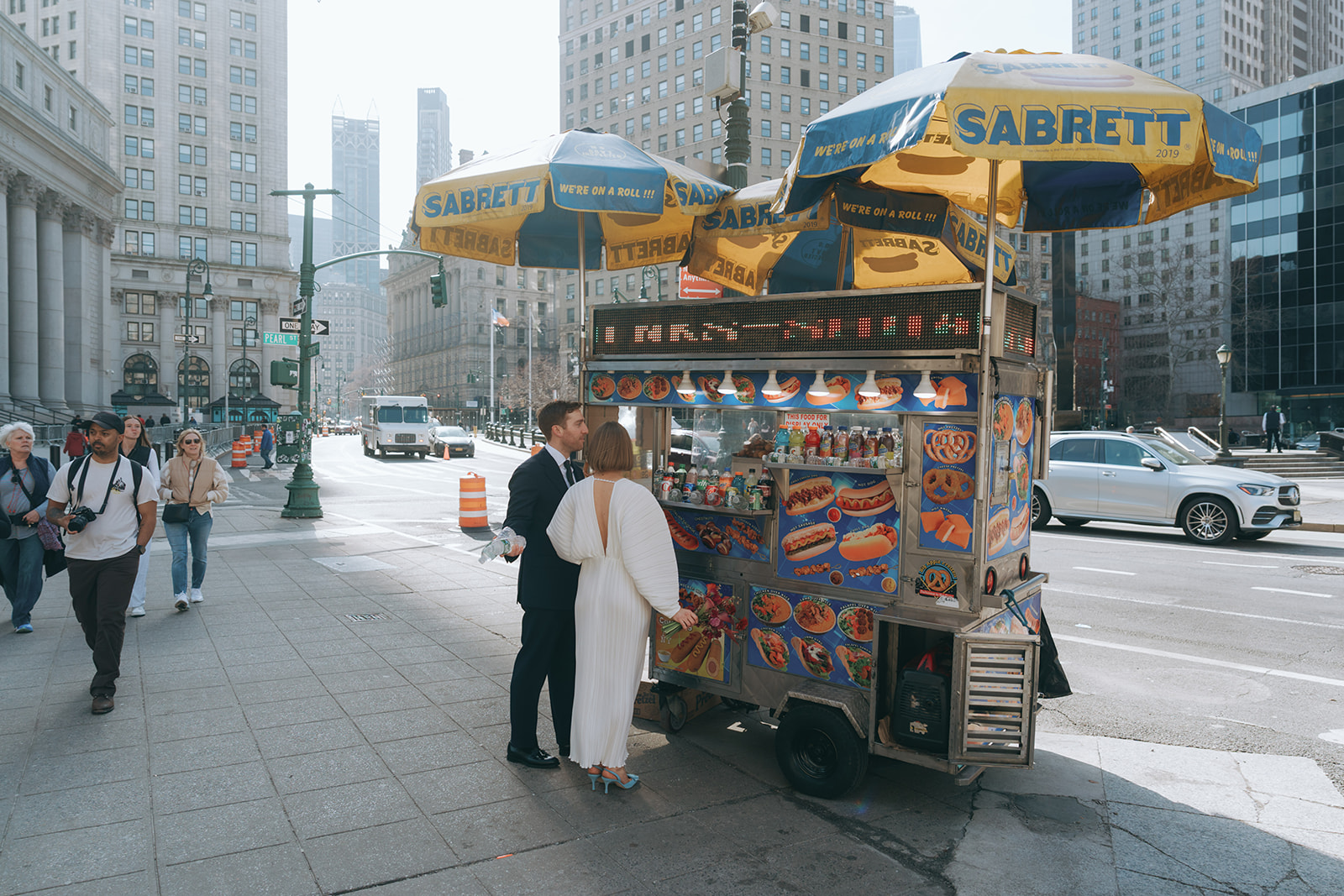 Rachel and Dave’s 2 day celebration Bride and groom at the hot dog cart outside of NY city hall by NYC city hall wedding photographer Elsie Goodman.