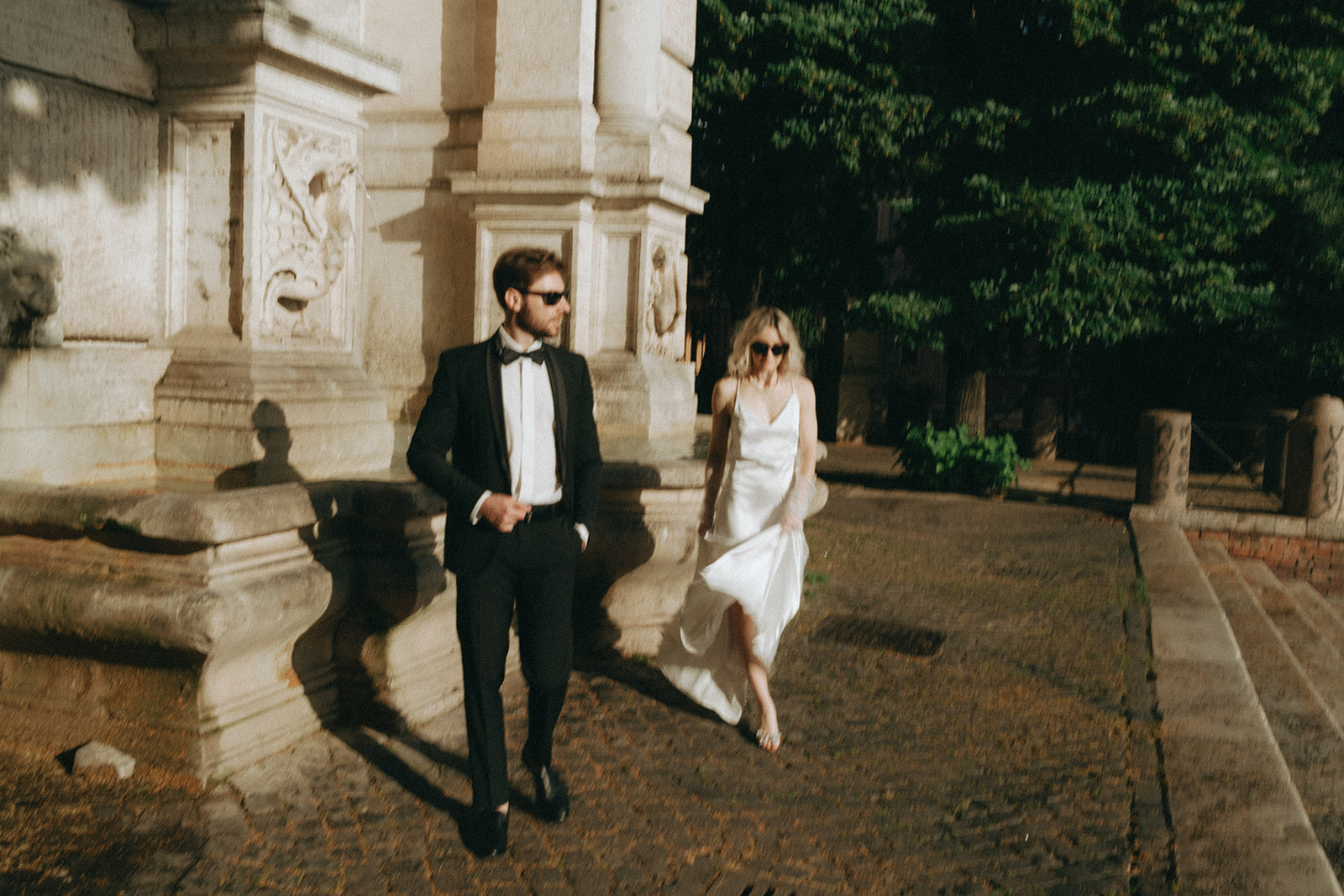 action shot of the bride and groom walking in the golden morning light by Rome elopement photographer Elsie Goodman.