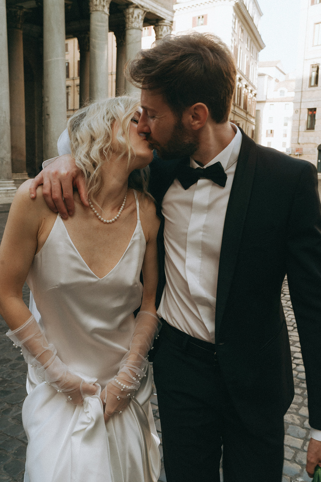 Bride and groom kissing in front of the Pantheon in Rome by Italy elopement photographer Elsie Goodman.