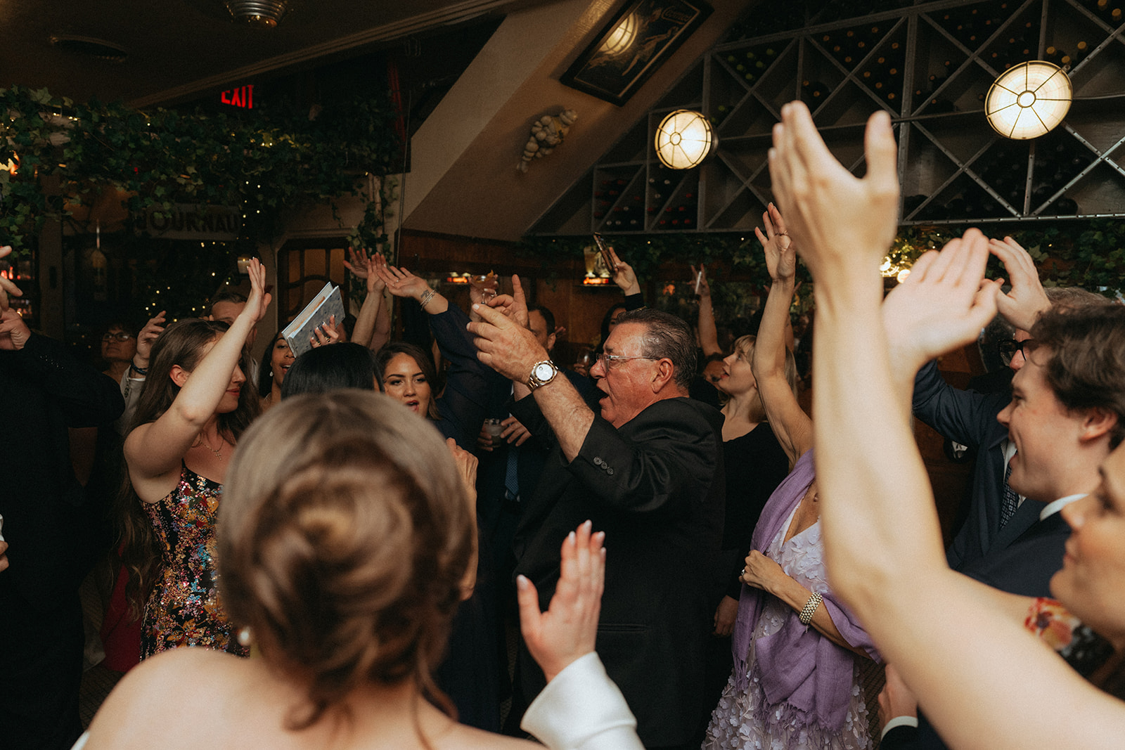 Madison + Dylan 620 Loft and Garden Wedding crowd dancing with hands in the air at wedding reception at Juliette’s in nyc, shot by elsie goodman, a destination and NYC wedding photographer