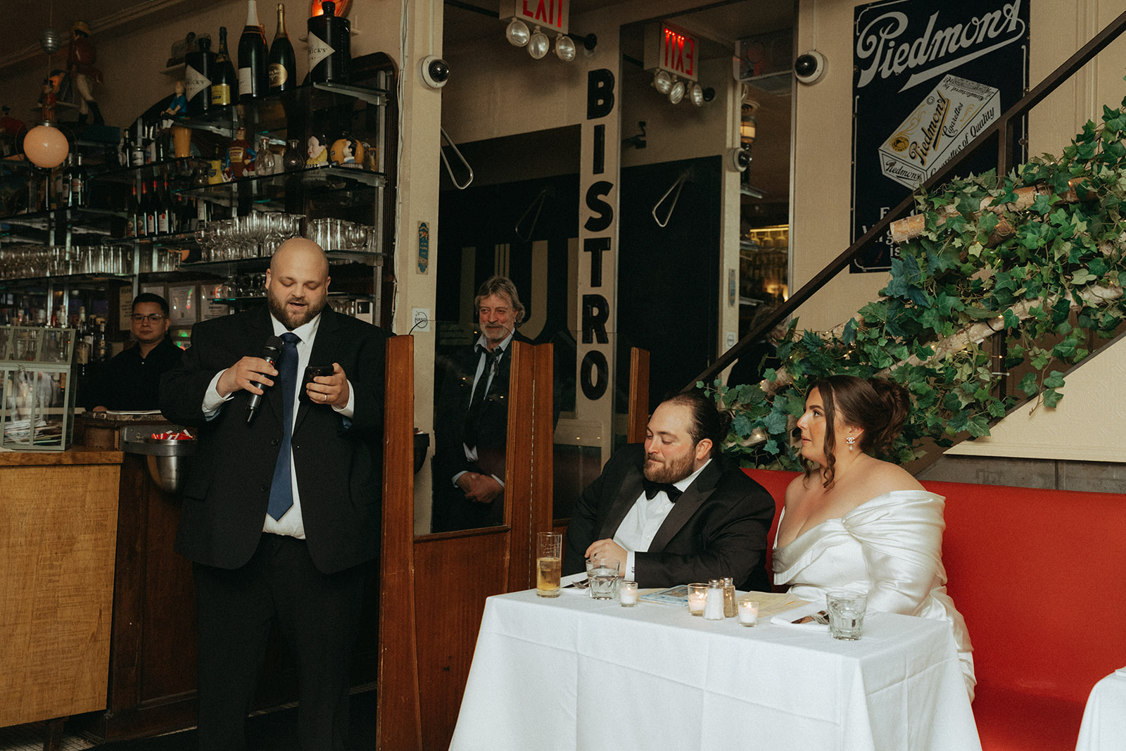 Madison + Dylan 620 Loft and Garden Wedding bride and groom listening to a speech at wedding reception at Juliette’s in nyc, shot by elsie goodman, a destination and NYC wedding photographer