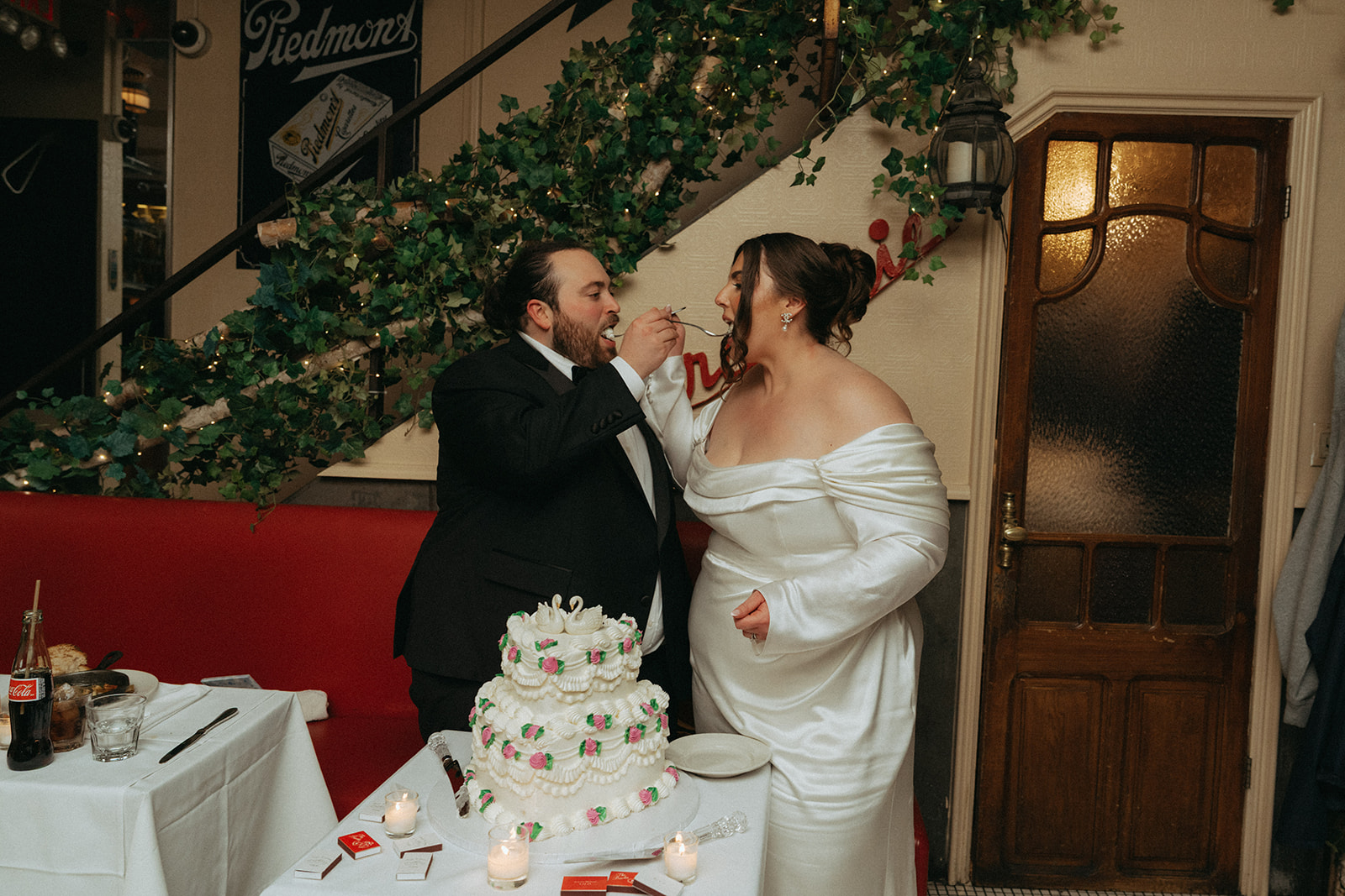 Madison + Dylan 620 Loft and Garden Wedding bride and groom feeding each other cake at wedding reception at Juliette’s in nyc, shot by elsie goodman, a destination and NYC wedding photographer