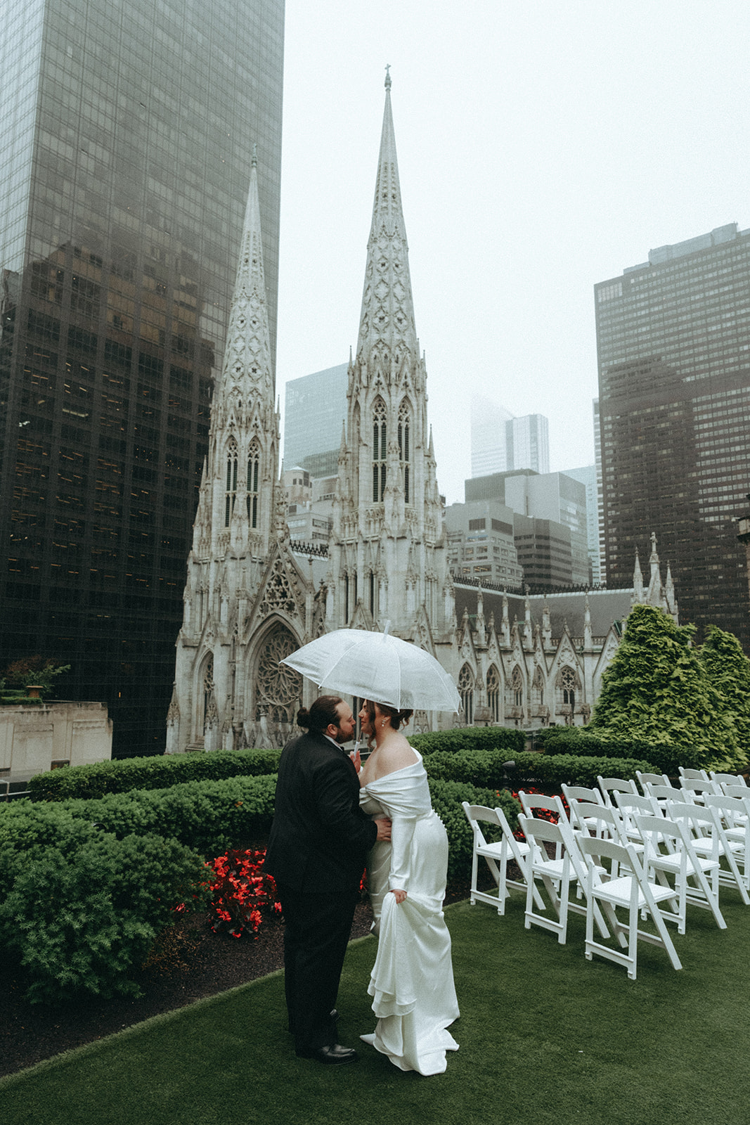 Madison + Dylan 620 Loft and Garden Wedding bride and groom kissing under umbrella on rooftop at 620 loft & garden wedding, shot by elsie goodman, a destination and NYC wedding photographer