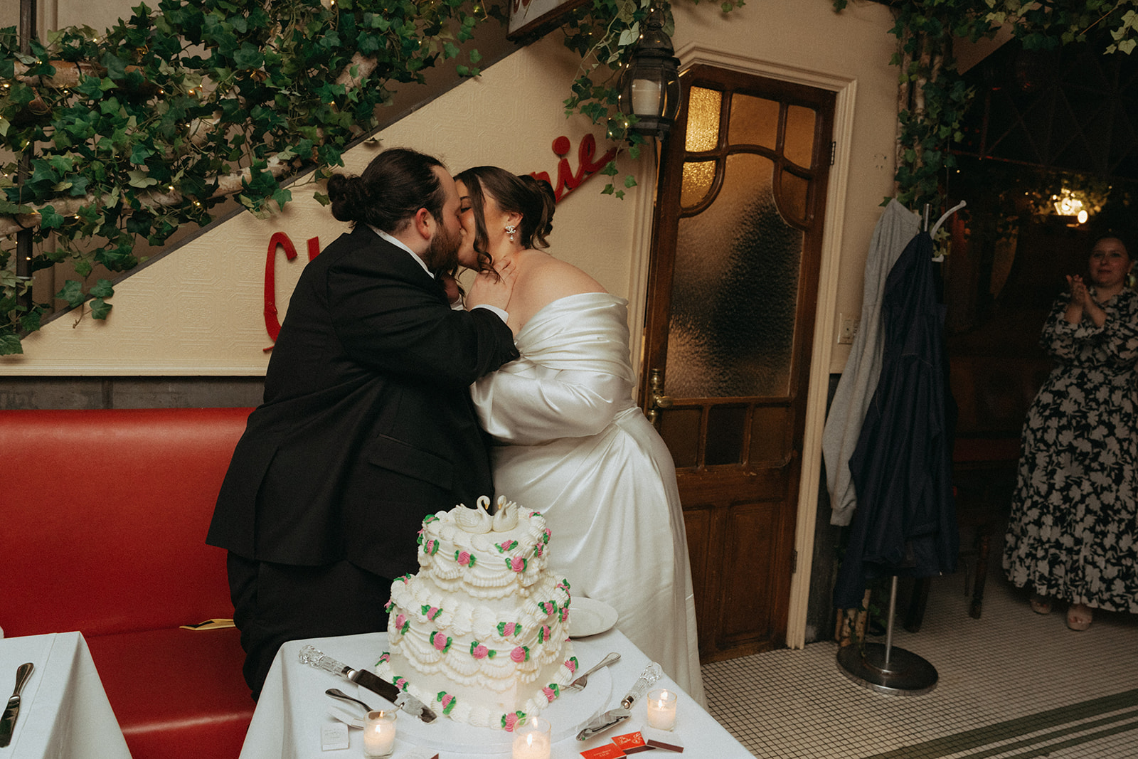 Madison + Dylan 620 Loft and Garden Wedding bride and groom kissing in front of vintage tiered cake at wedding reception at Juliette’s in nyc, shot by elsie goodman, a destination and NYC wedding photographer