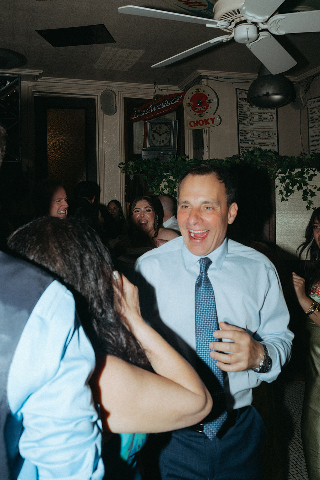 Madison + Dylan 620 Loft and Garden Wedding candid photo of man smiling at wedding reception at Juliette’s in nyc, shot by elsie goodman, a destination and NYC wedding photographer
