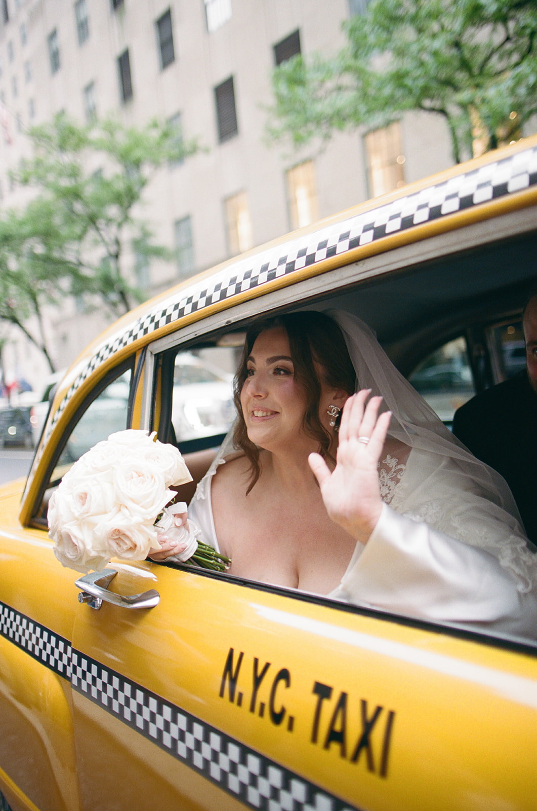 Madison + Dylan 620 Loft and Garden Wedding bride waving from window of vintage taxi after 620 loft & garden wedding, shot by elsie goodman, a destination and NYC wedding photographer