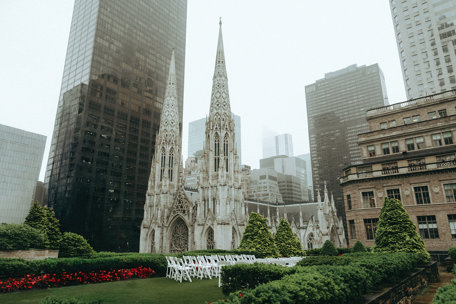 Madison + Dylan 620 Loft and Garden Wedding ceremony set up on rooftop with cathedral and buildings in the background at 620 loft & garden wedding, shot by elsie goodman, a destination and NYC wedding photographer