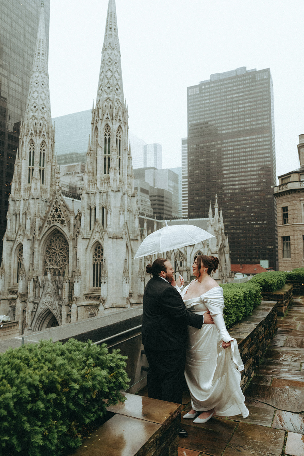 Madison + Dylan 620 Loft and Garden Wedding bride and groom holding each other under umbrella on rooftop at 620 loft & garden wedding, shot by elsie goodman, a destination and NYC wedding photographer