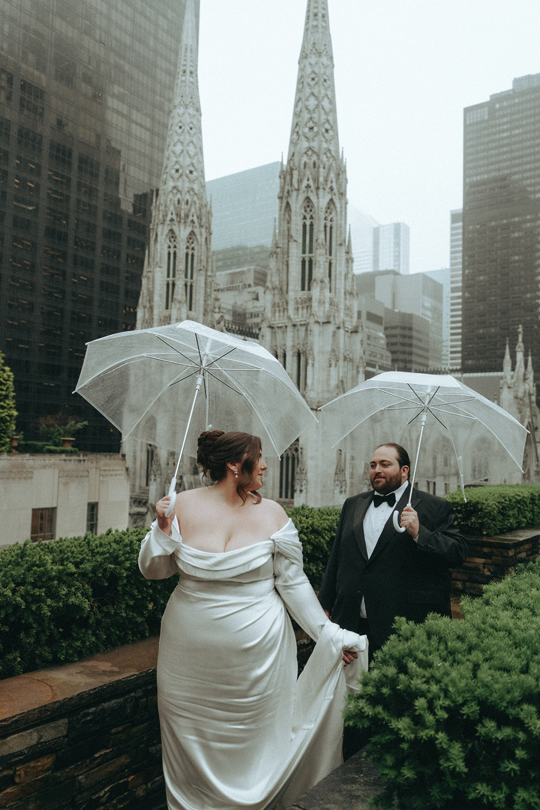 Madison + Dylan 620 Loft and Garden Wedding bride and groom walking with umbrellas on rooftop at 620 loft & garden wedding, shot by elsie goodman, a destination and NYC wedding photographer
