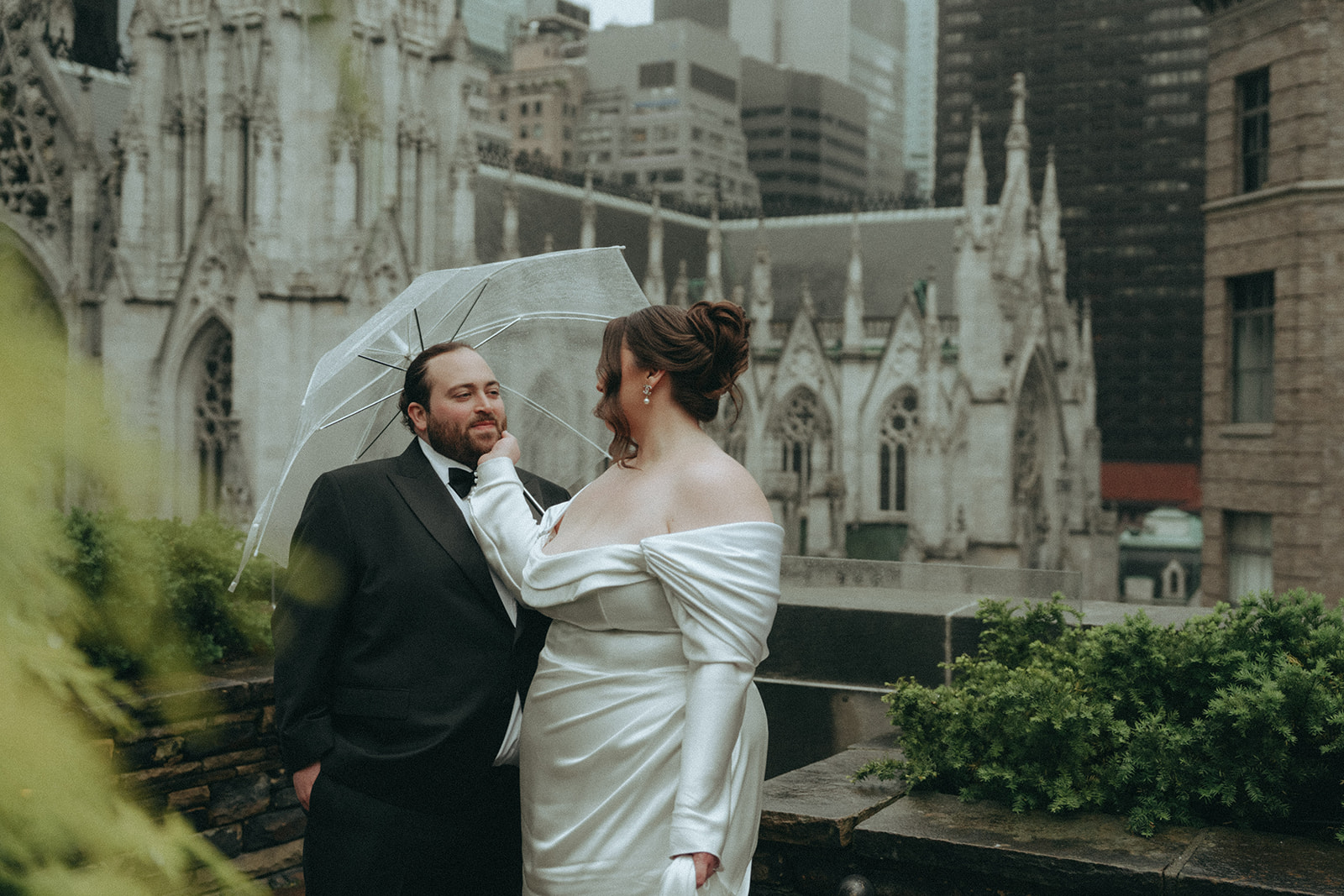 Madison + Dylan 620 Loft and Garden Wedding bride touches groom's face on rooftop with umbrella at 620 loft & garden wedding, shot by elsie goodman, a destination and NYC wedding photographer
