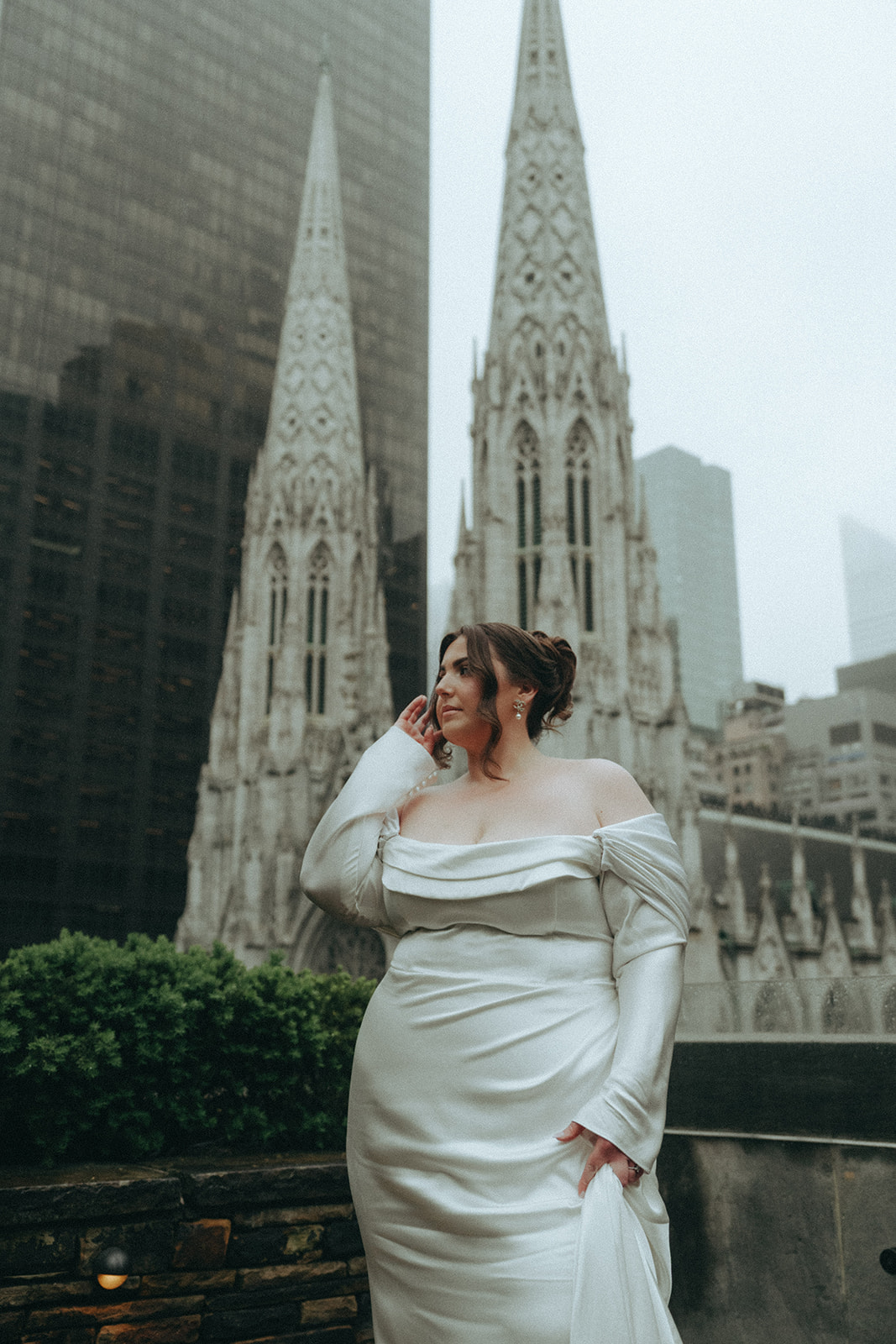 Madison + Dylan 620 Loft and Garden Wedding bride posing for portraits on rooftop with cathedral in the background at 620 loft & garden wedding, shot by elsie goodman, a destination and NYC wedding photographer