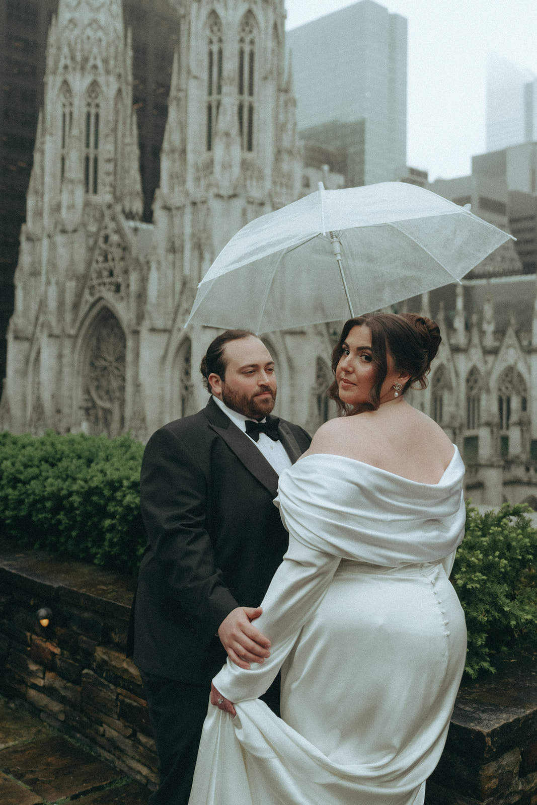 Madison + Dylan 620 Loft and Garden Wedding groom looking at bride under umbrella on rooftop at 620 loft & garden wedding, shot by elsie goodman, a destination and NYC wedding photographer