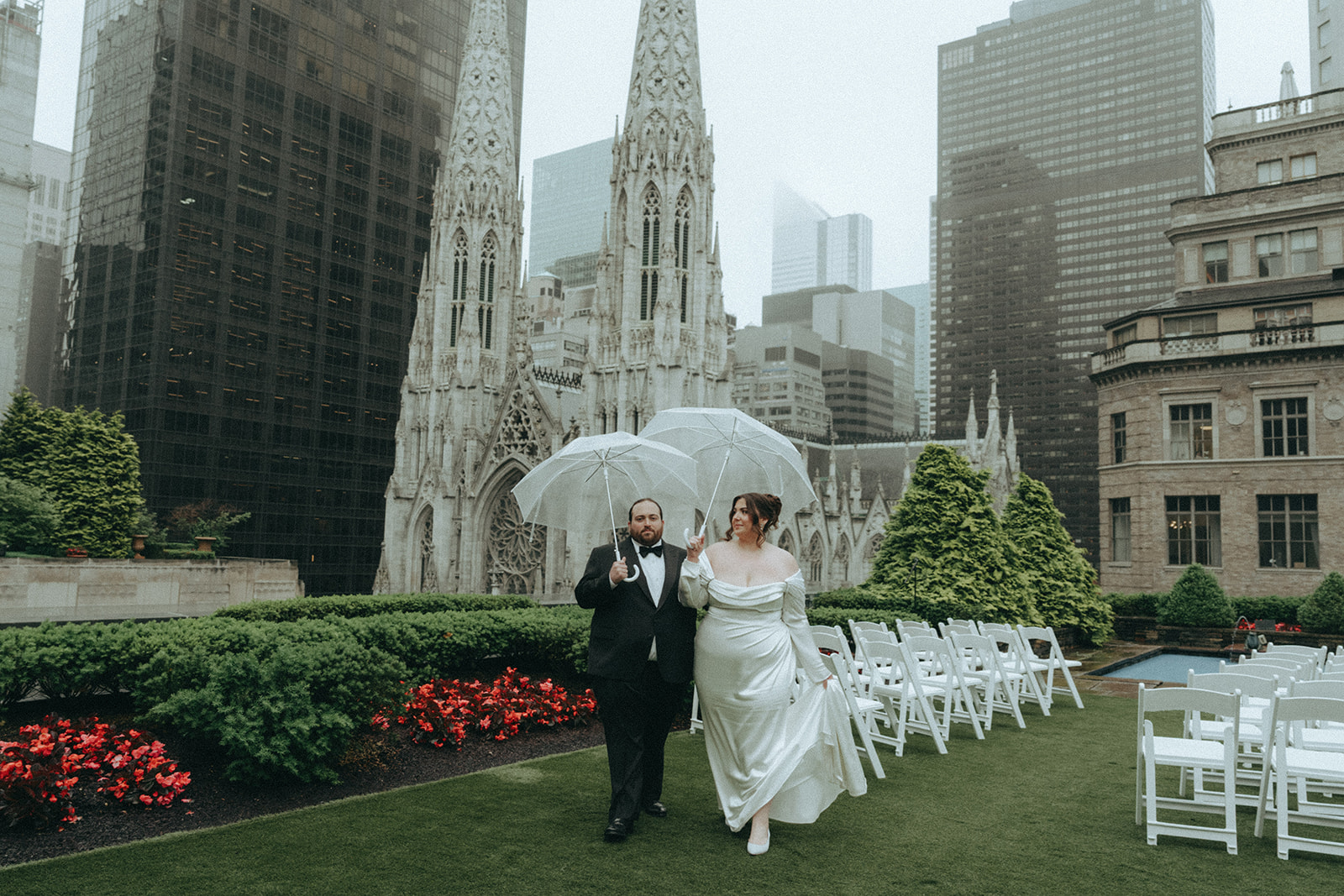 Madison + Dylan 620 Loft and Garden Wedding bride and groom walking with umbrellas on rooftop at 620 loft & garden wedding, shot by elsie goodman, a destination and NYC wedding photographer