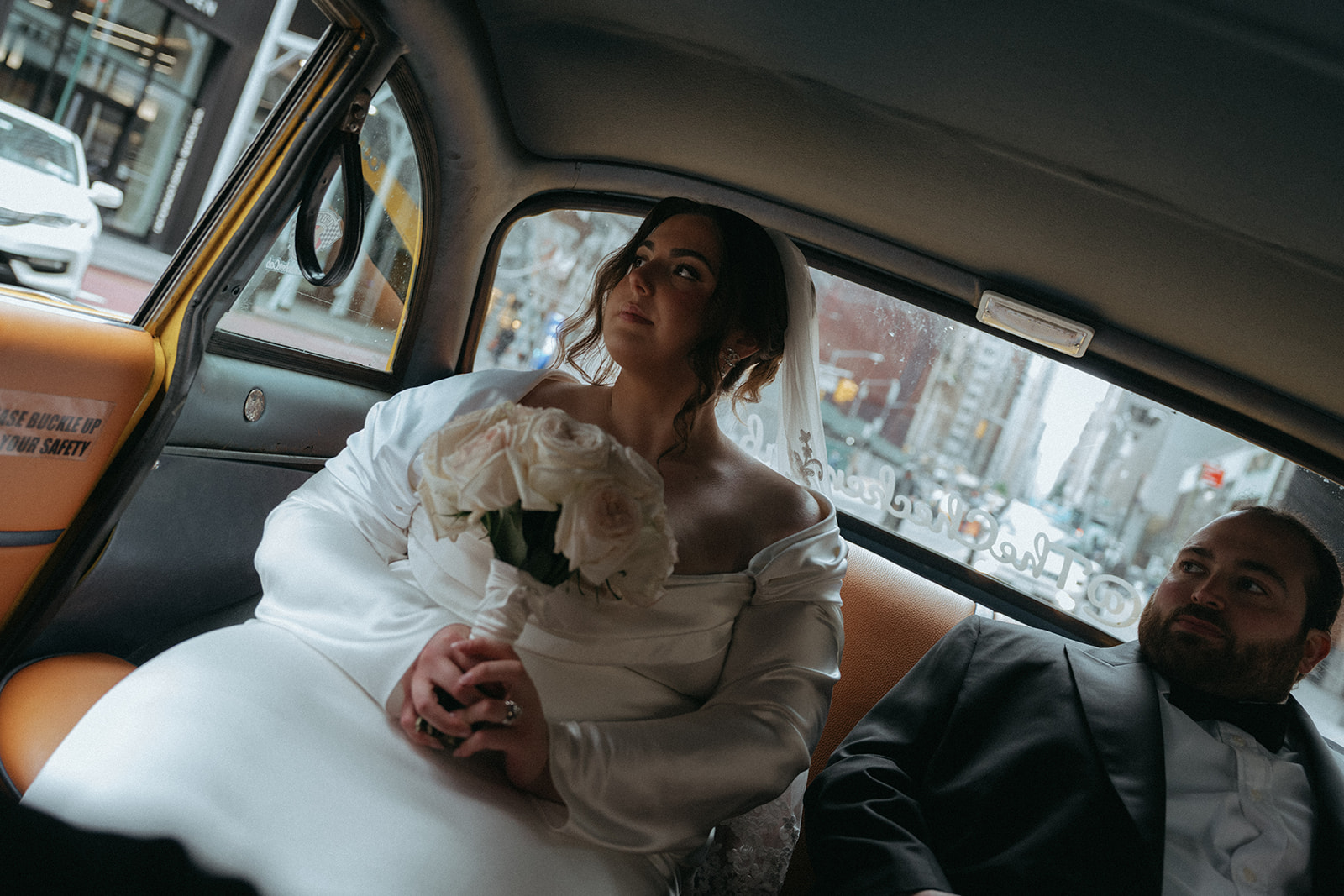 Madison + Dylan 620 Loft and Garden Wedding bride and groom riding in backseat of vintage taxi after 620 loft & garden wedding, shot by elsie goodman, a destination and NYC wedding photographer