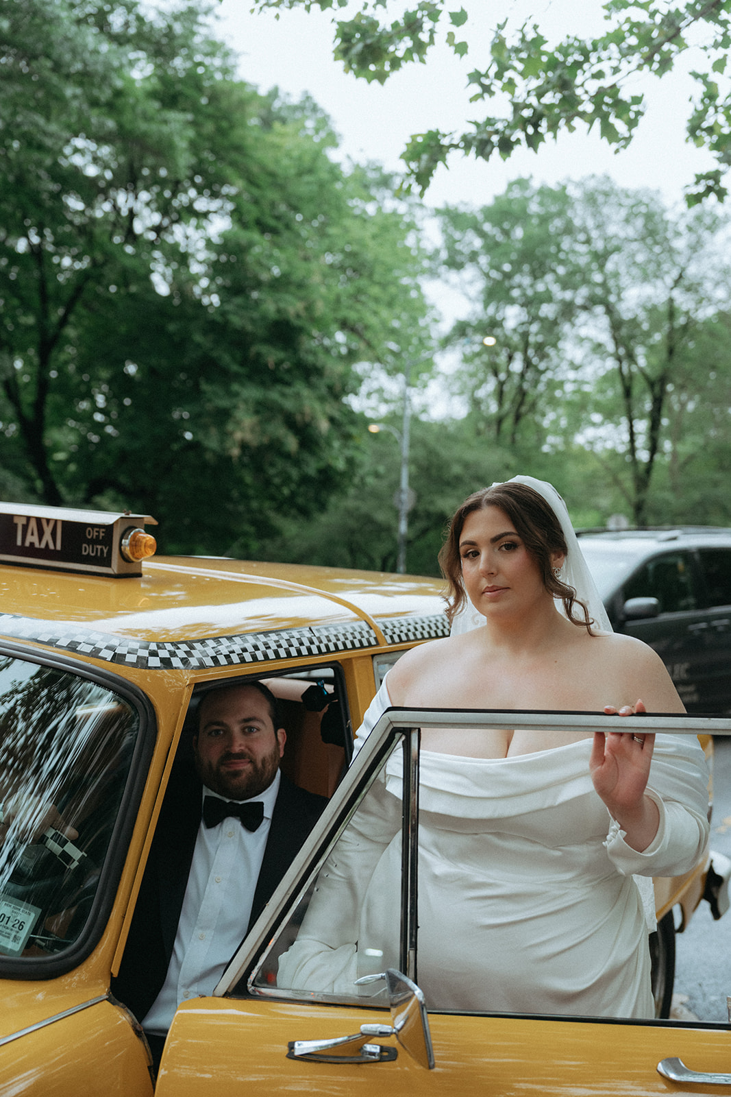 Madison + Dylan 620 Loft and Garden Wedding bride and groom posing with vintage taxi after 620 loft & garden wedding, shot by elsie goodman, a destination and NYC wedding photographer