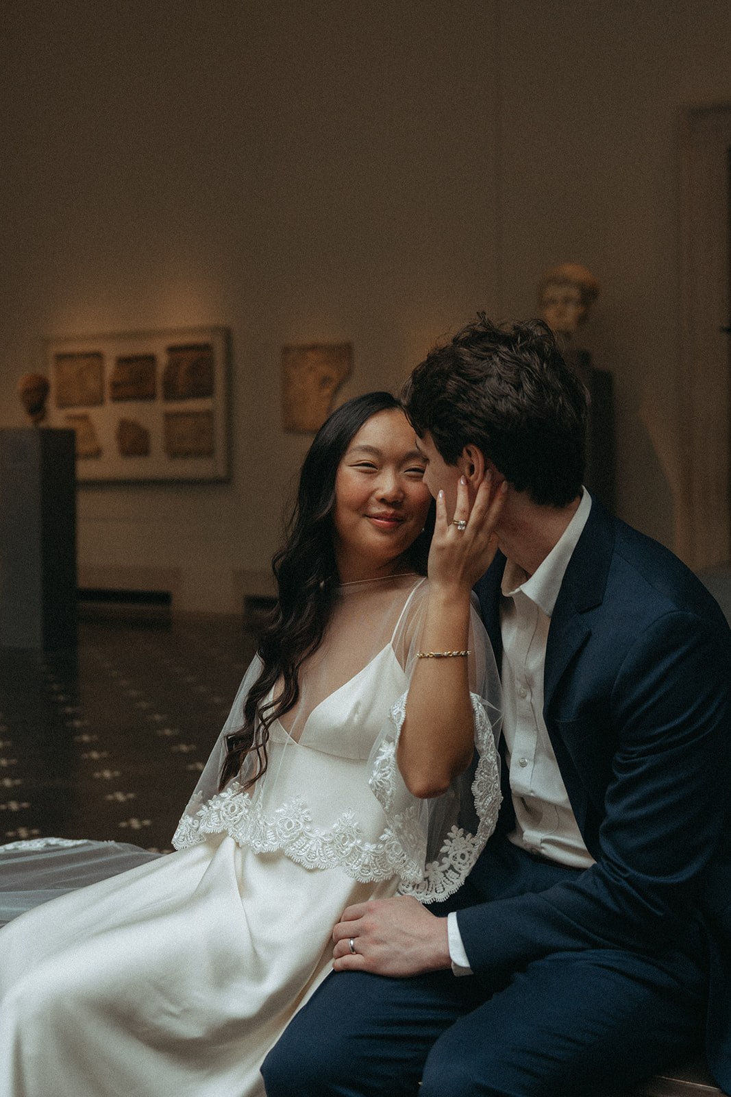 Alex + Bardo NYC Elopement Photos bride touching groom's face on a bench at the Met for elopement photos, shot by elsie goodman, a destination, wedding and NYC elopement photographer
