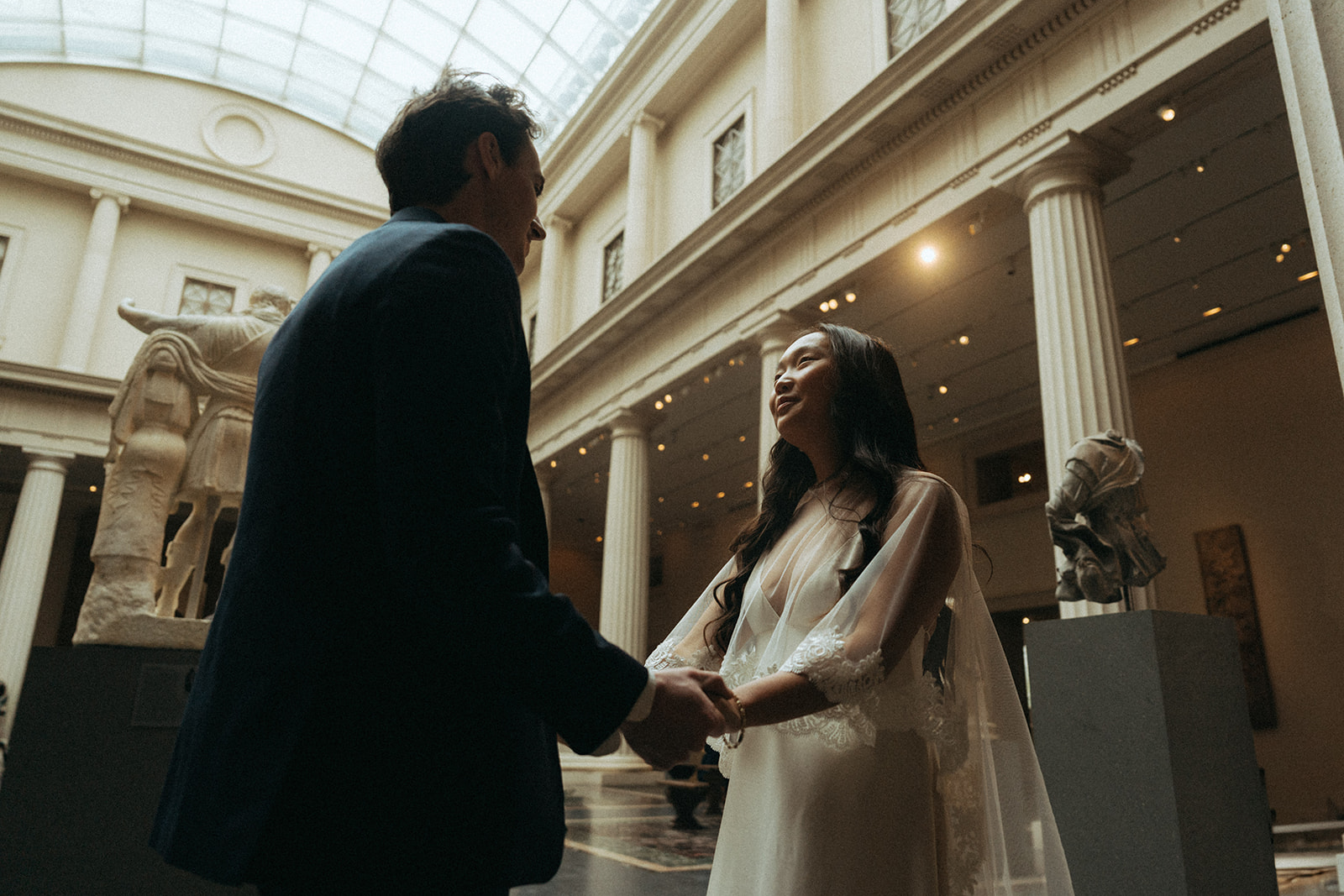 Alex + Bardo NYC Elopement Photos bride and groom holding hands in a sculpture gallery at the Met shot by elsie goodman, a destination, wedding and NYC elopement photographer