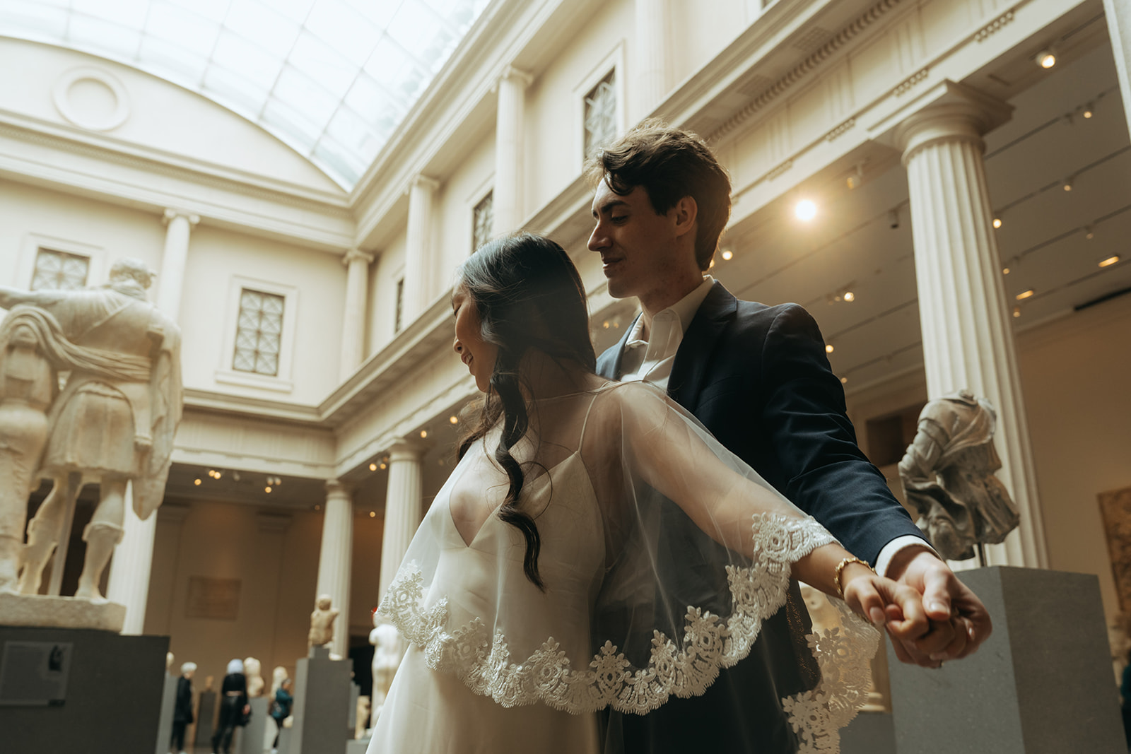 Alex + Bardo NYC Elopement Photos bride and groom holding hands in the Met sculpture gallery for elopement photos, shot by elsie goodman, a destination, wedding and NYC elopement photographer