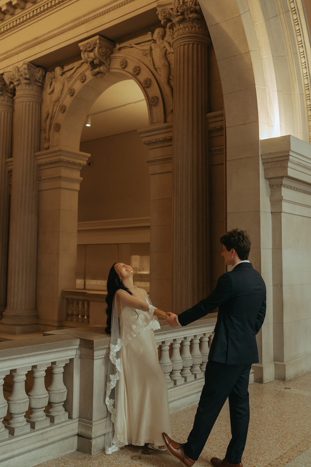 Alex + Bardo NYC Elopement Photos bride holding groom's hand under arch at the Met for elopement photos, shot by elsie goodman, a destination, wedding and NYC elopement photographer
