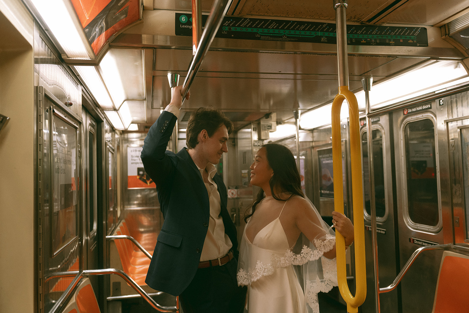 Alex + Bardo NYC Elopement Photos bride and groom looking at each other on the NYC Subway, shot by elsie goodman, a destination, wedding and NYC elopement photographer