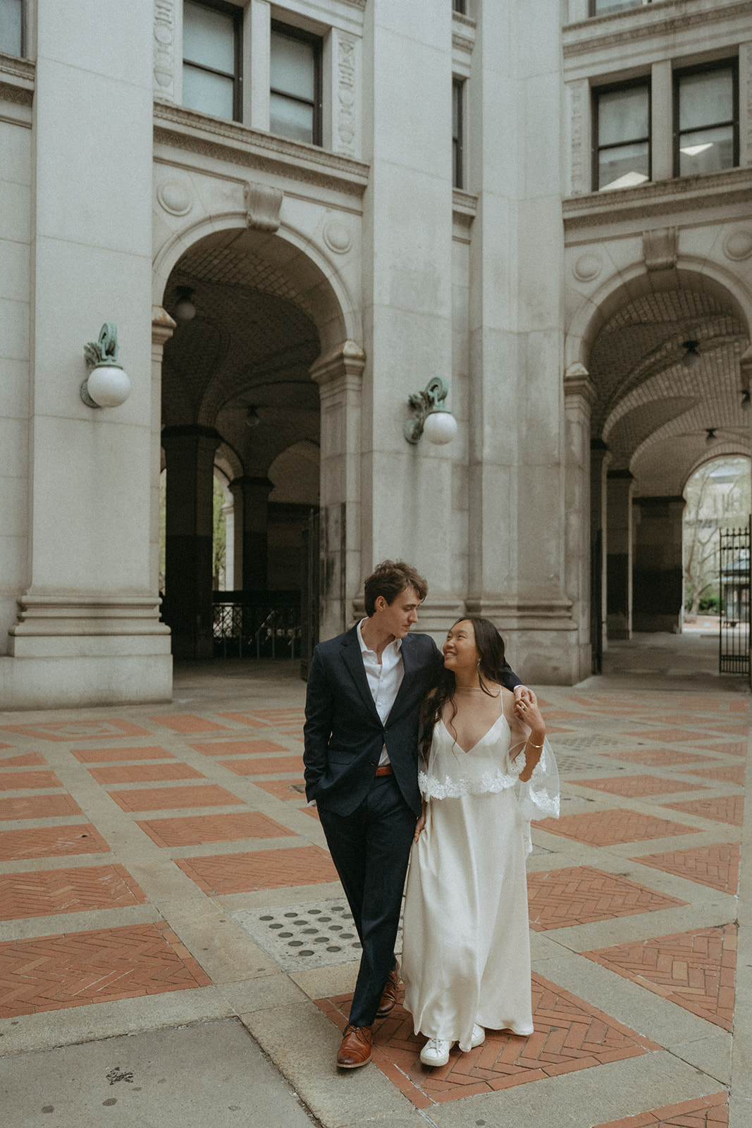 Alex + Bardo NYC Elopement Photos bride and groom walking outside of city hall before eloping, shot by elsie goodman, a destination, wedding and NYC elopement photographer