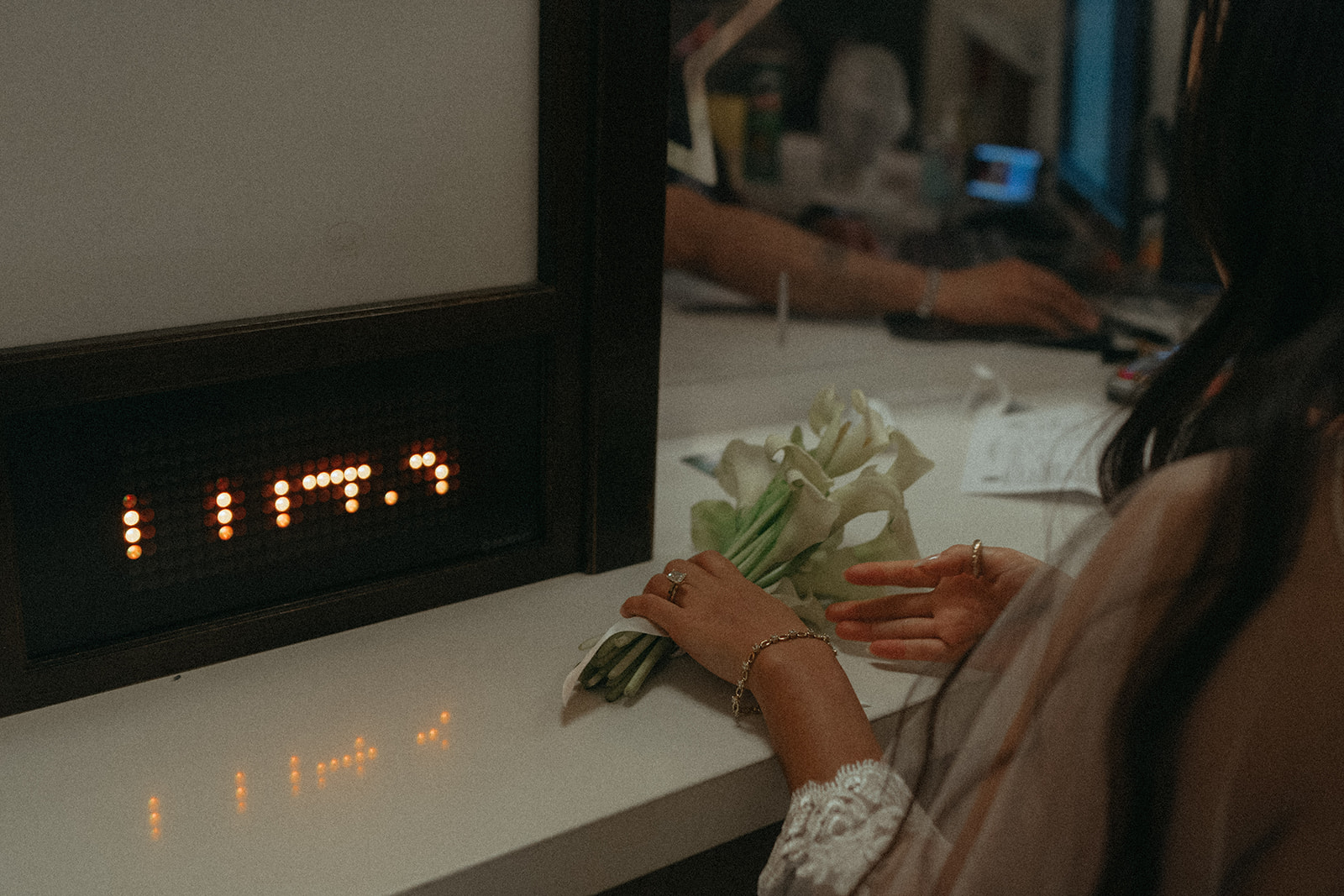 Alex + Bardo NYC Elopement Photos bride registering to elope at city hall desk with flowers, shot by elsie goodman, a destination, wedding and NYC elopement photographer