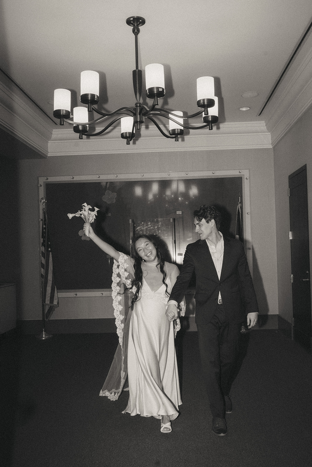 Alex + Bardo NYC Elopement Photos bride and groom holding hands and walking after getting married at city all, shot by elsie goodman, a destination, wedding and NYC elopement photographer