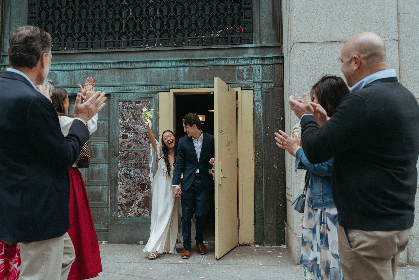 Alex + Bardo NYC Elopement Photos bride and groom coming out of city hall after getting married, shot by elsie goodman, a destination, wedding and NYC elopement photographer