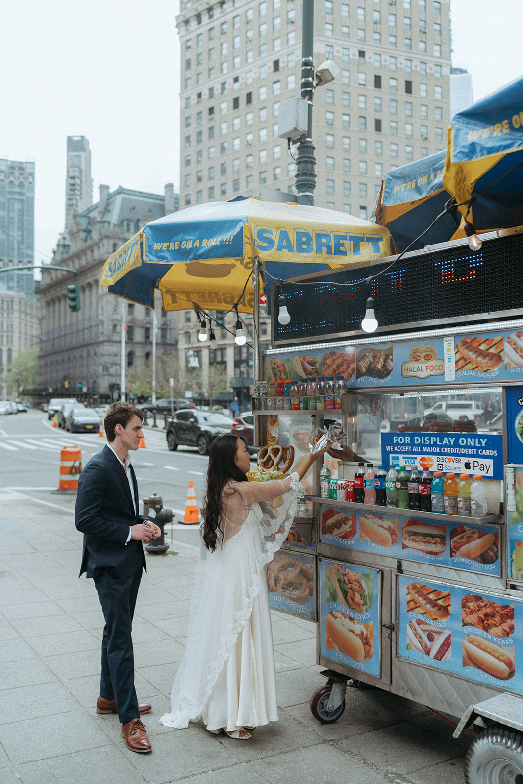 Alex + Bardo NYC Elopement Photos bride and groom getting hot dogs after NYC city hall wedding, shot by elsie goodman, a destination, wedding and NYC elopement photographer