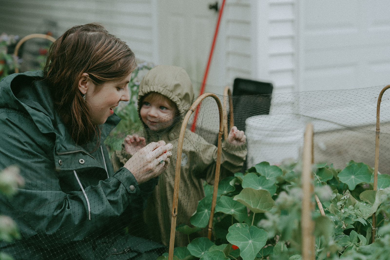 Mom and child in the garden together on a rainy day by maternity, family, and wedding photographer Elsie Goodman.