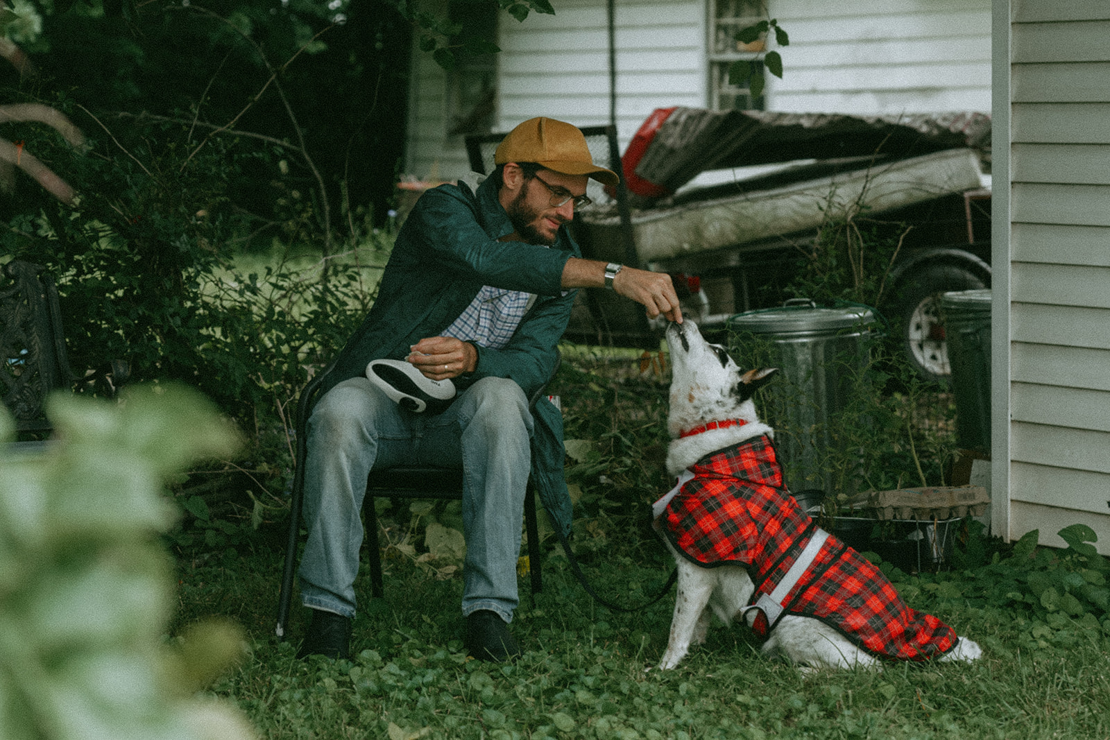 Dad feeding the dog a treat by maternity, family, and wedding photographer Elsie Goodman.