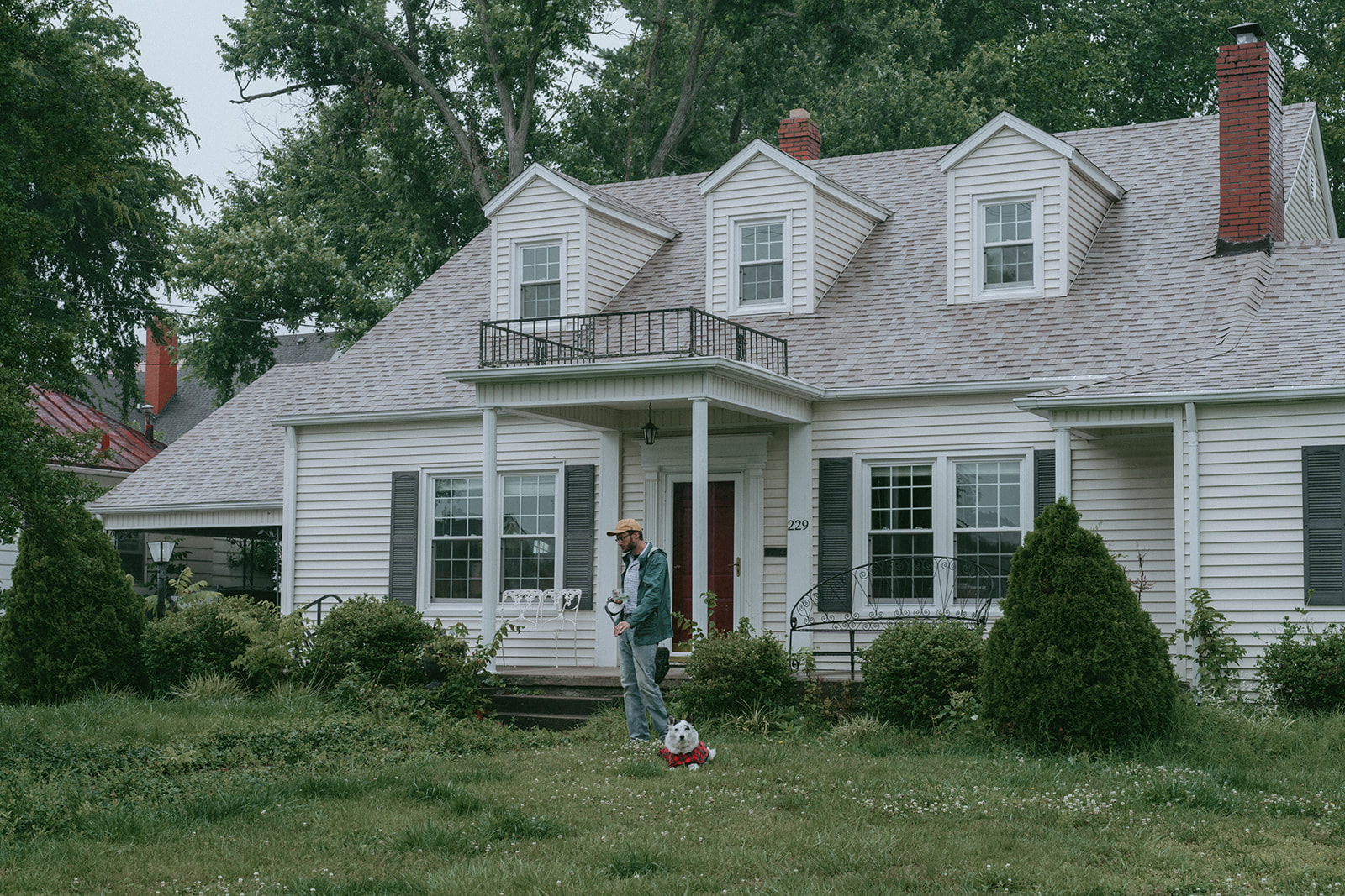 Dad standing in the front yard with the dog by maternity, family, and wedding photographer Elsie Goodman.
