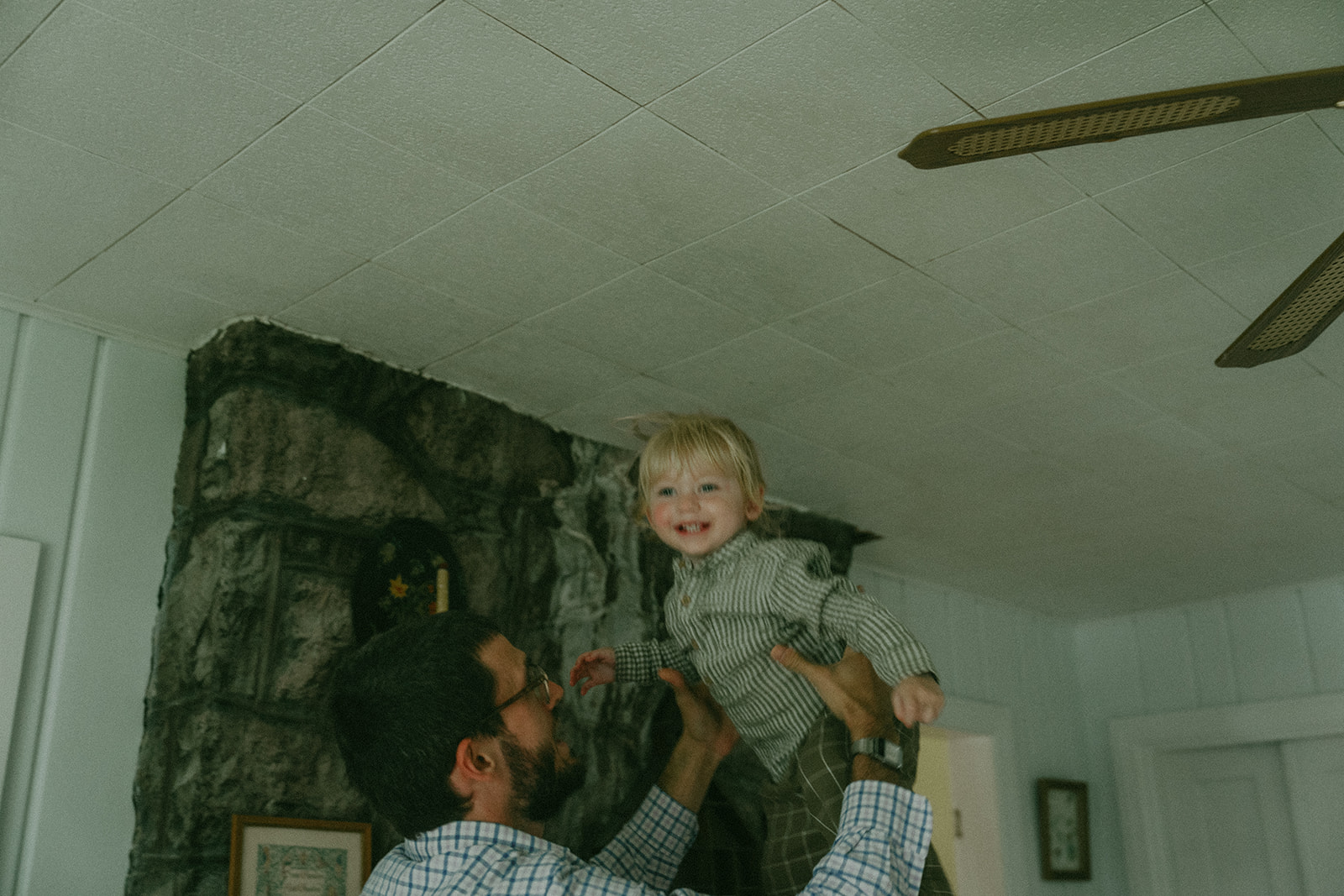 Dad holding his child above his head by maternity, family, and wedding photographer Elsie Goodman.