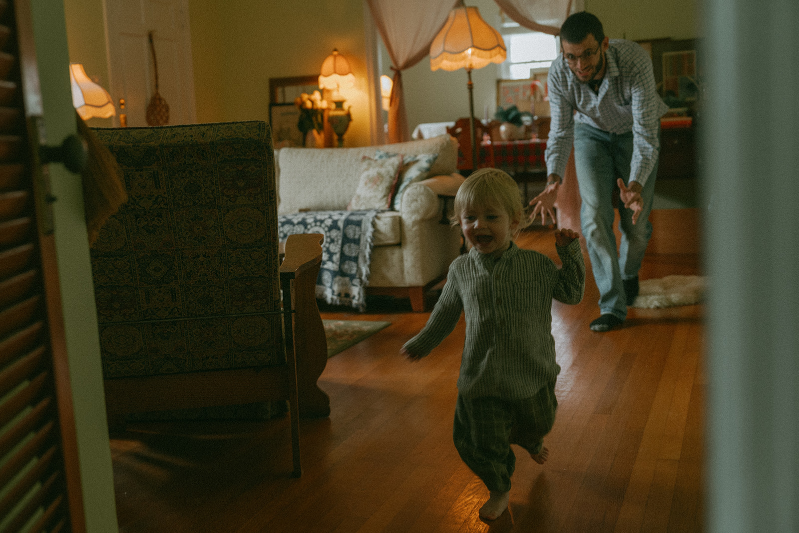 Dad chases child through the house by maternity, family, and wedding photographer Elsie Goodman.