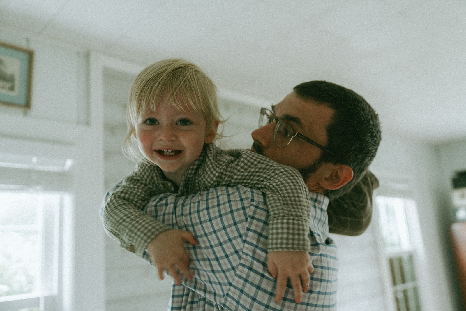 Dad holds child up, playing with them by maternity, family, and wedding photographer Elsie Goodman.