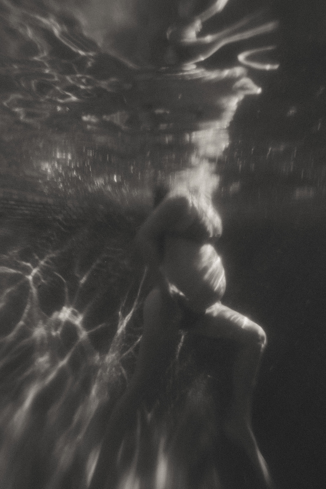 Pregnant women in a bikini photographed underwater by maternity photographer Elsie Goodman.