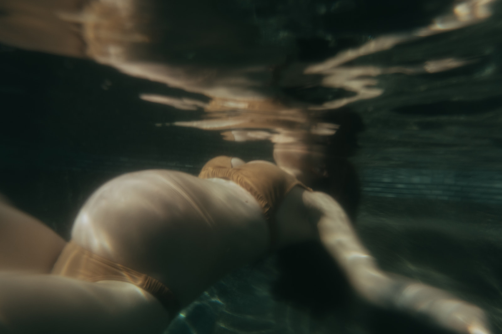 Pregnant women in a bikini photographed underwater by maternity photographer Elsie Goodman.