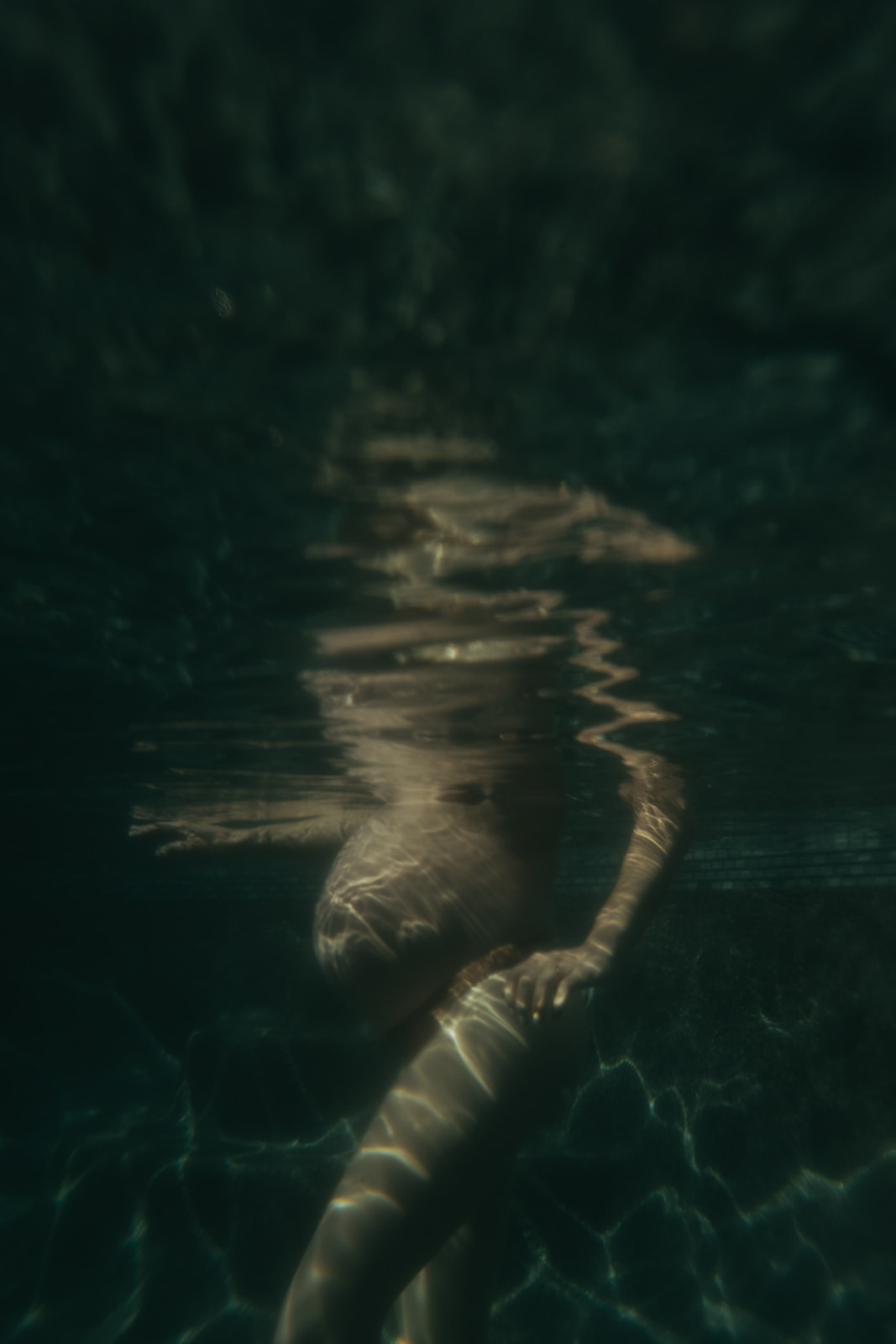 Pregnant women in a bikini photographed underwater by maternity photographer Elsie Goodman.
