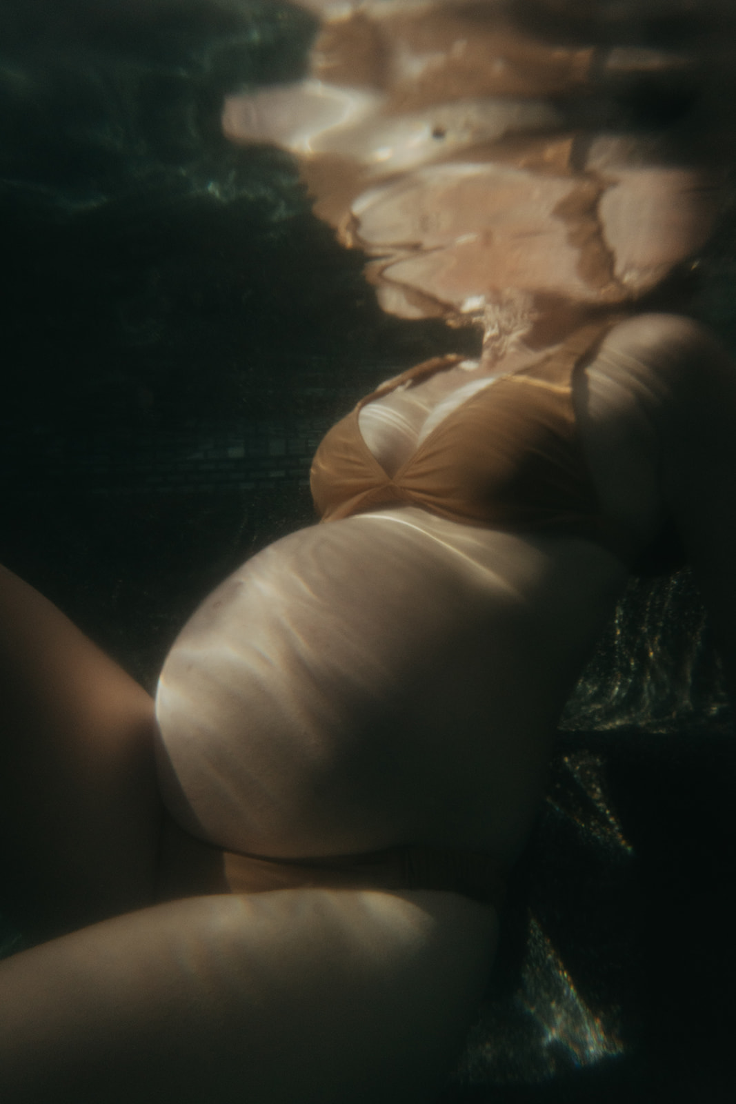 Pregnant women in a bikini photographed underwater by maternity photographer Elsie Goodman.