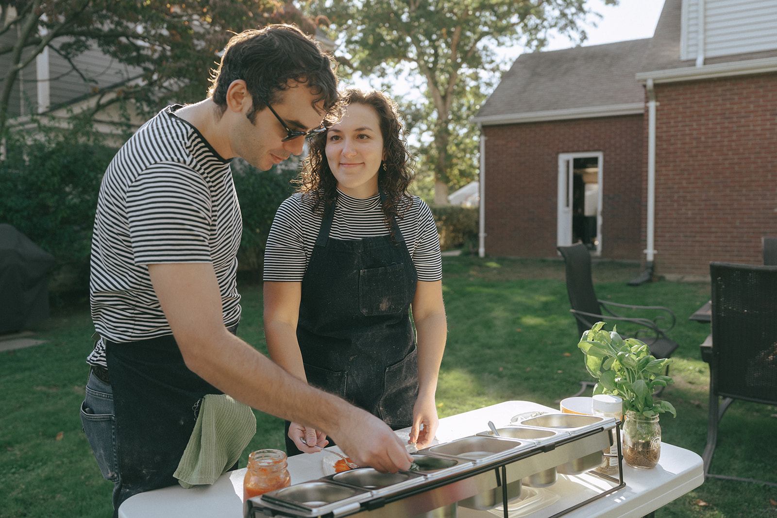 Couple making pizza in the backyard by couples photographer, Elsie Goodman.